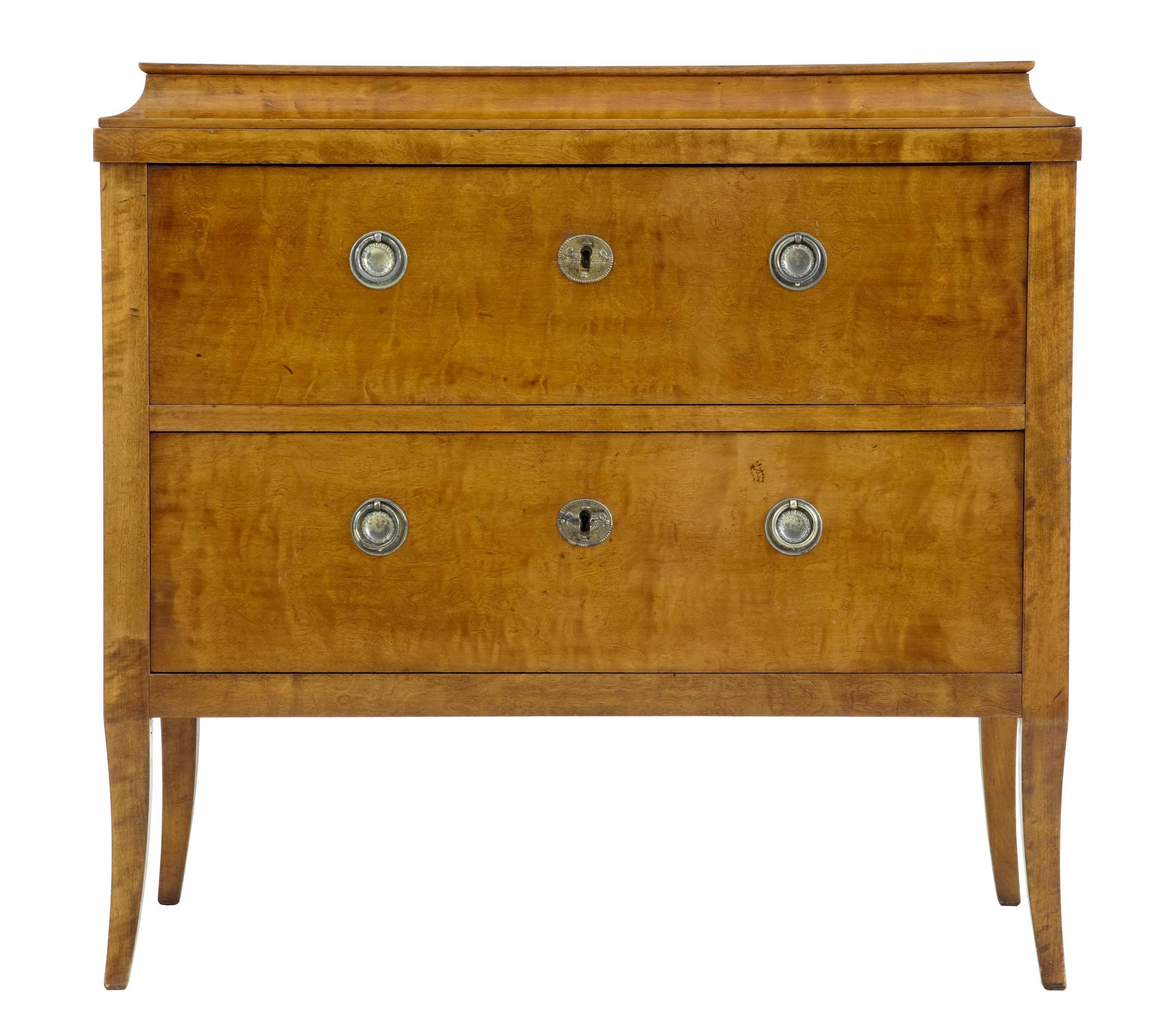 Stunning small birch commode, circa 1900.
Good color and patina on this chest which is very much in the Empire style.
Replaced handles, which are older than the chest but in keeping with the style.
Two drawers with one key.
Standing on tapering