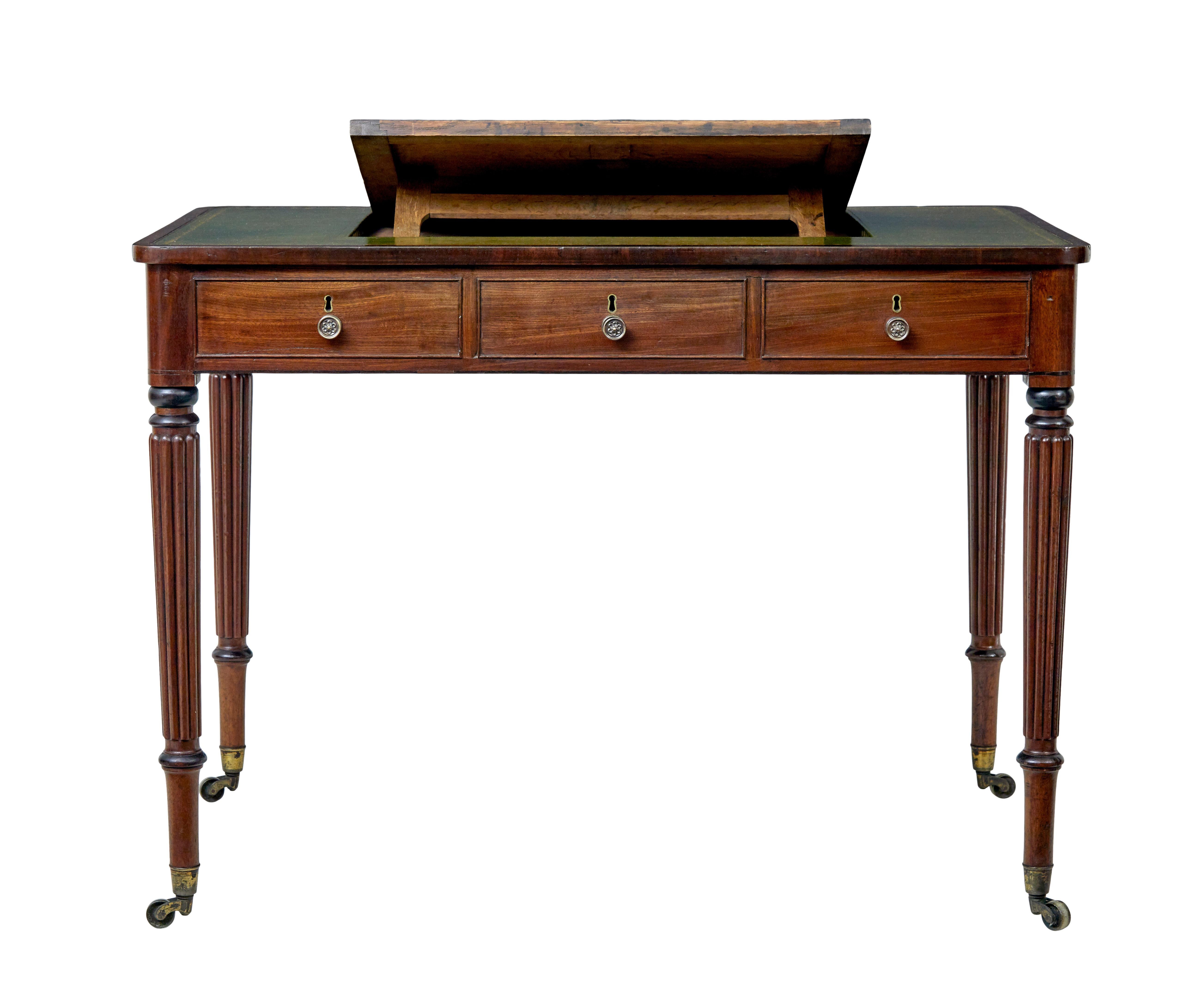 Late Georgian mahogany and leather architects desk circa 1810.

Green leather writing surface with gold tooling to the border. Set in the top and using the brass handle the slope can rise to various angles. Rounded corners to the rectangular top. 3