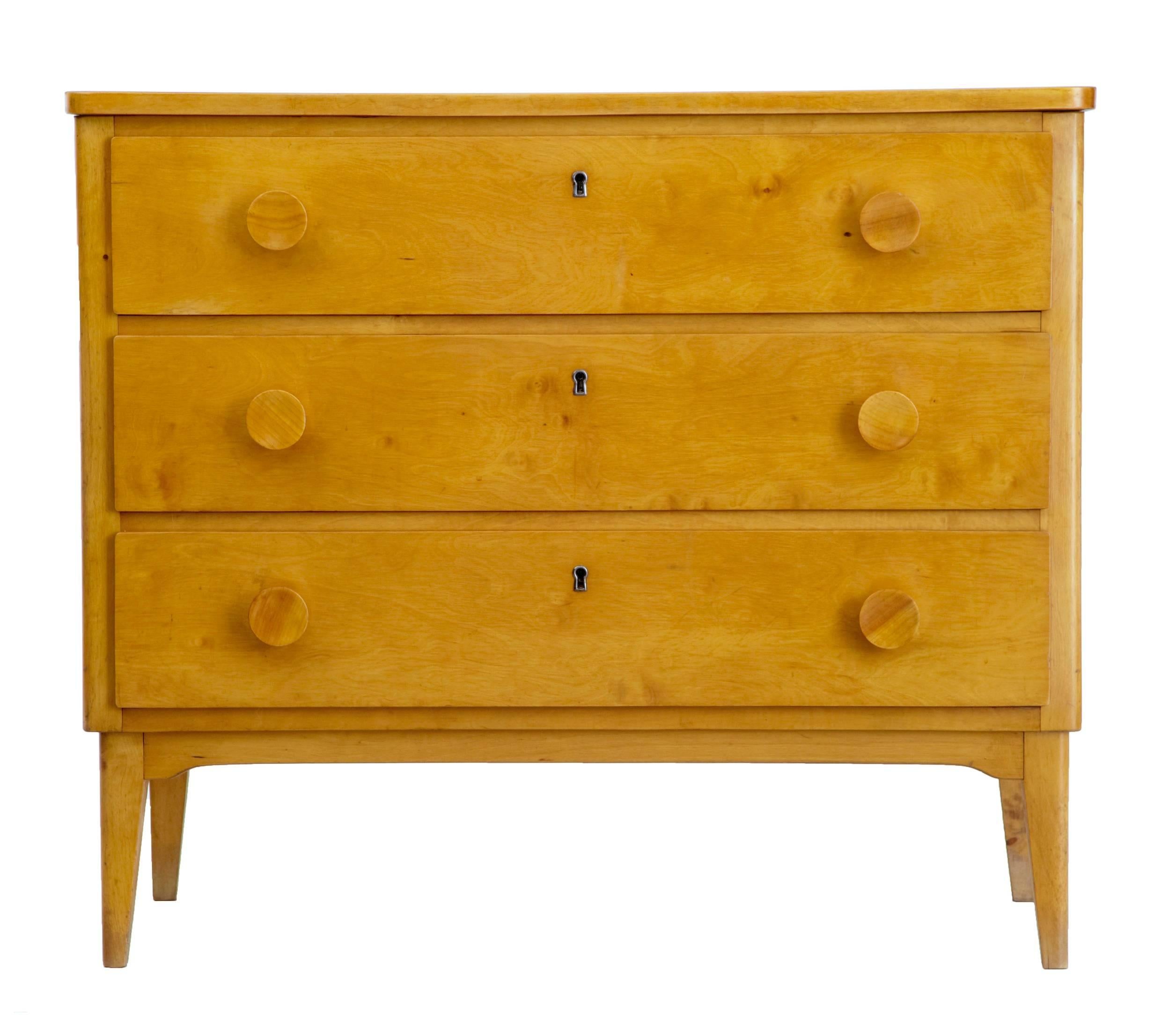 Golden birch chest of drawers, circa 1960.
Three drawers with matching handles.
Art Deco in taste.
Standing on tapering legs.

No key.

Measures: Height 28 1/4