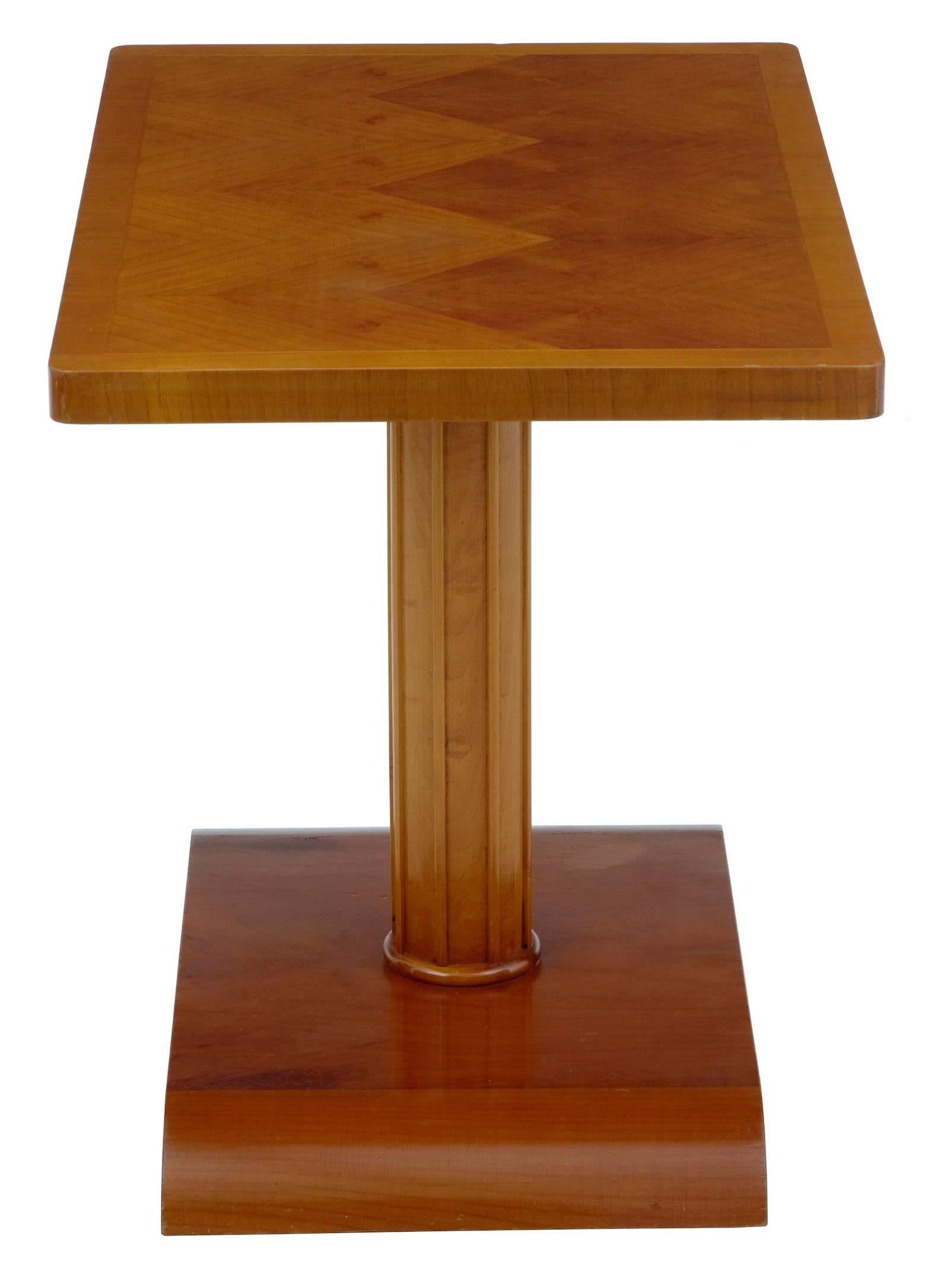 Rich colored birch occasional table, circa 1960.
Contrasting veneers to the top, standing on a fluted stem and shaped base.

One scratch and marks to top. Cracking to polish.

Measures: Height 22 3/4