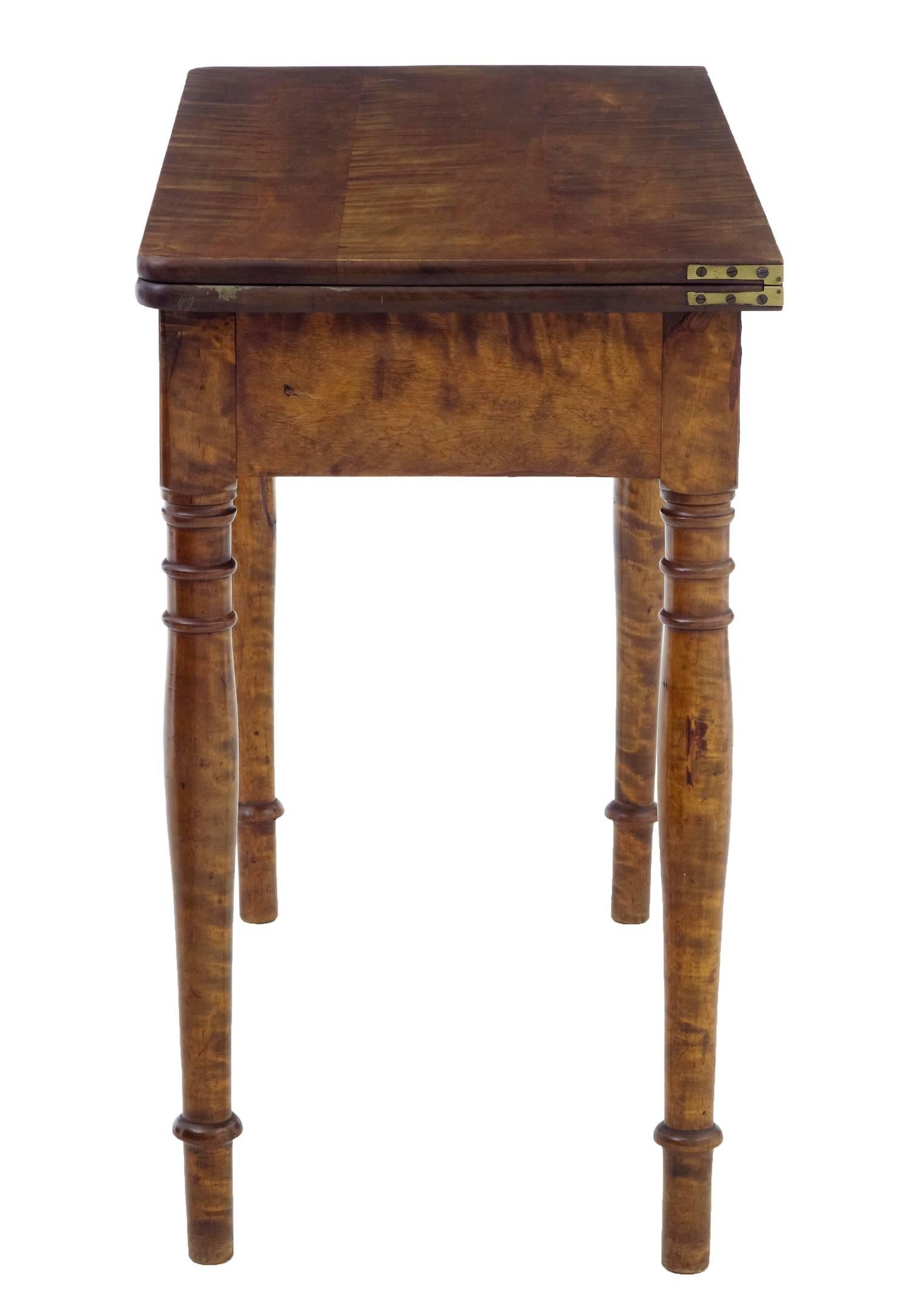 Functional birch card table, circa 1900.
Top opens and rotates to form a larger surface, with storage well underneath.
Standing on turned legs.

1 very small indentation to one end.

Measures: Height 30