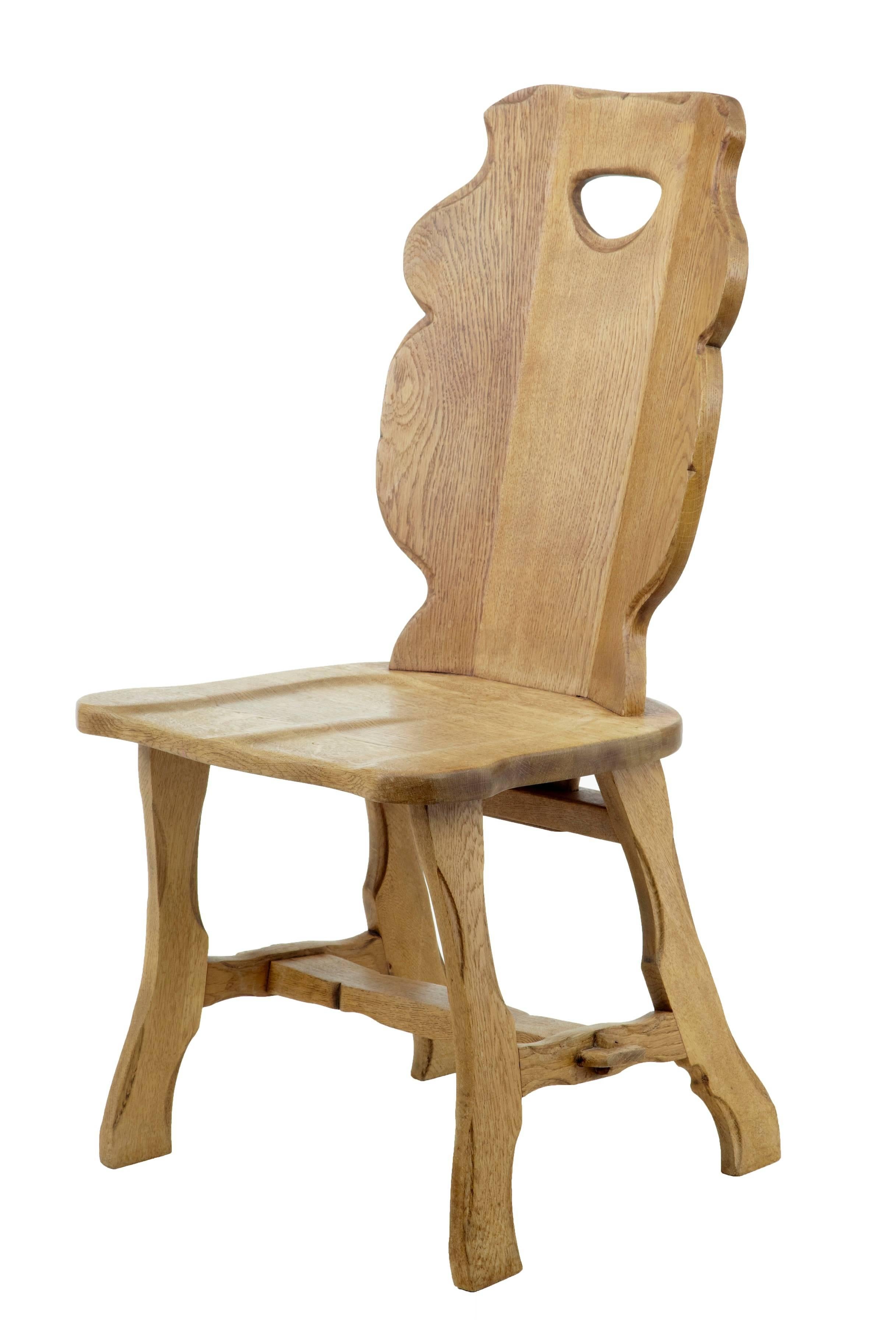 Unusual set of ten solid oak dining chairs, circa 1920.
Dug out backs, with shaped seat.
Very much inspired by the arts and crafts movement.
Legs supported by stretchers and pegs.

Height: 38 3/4