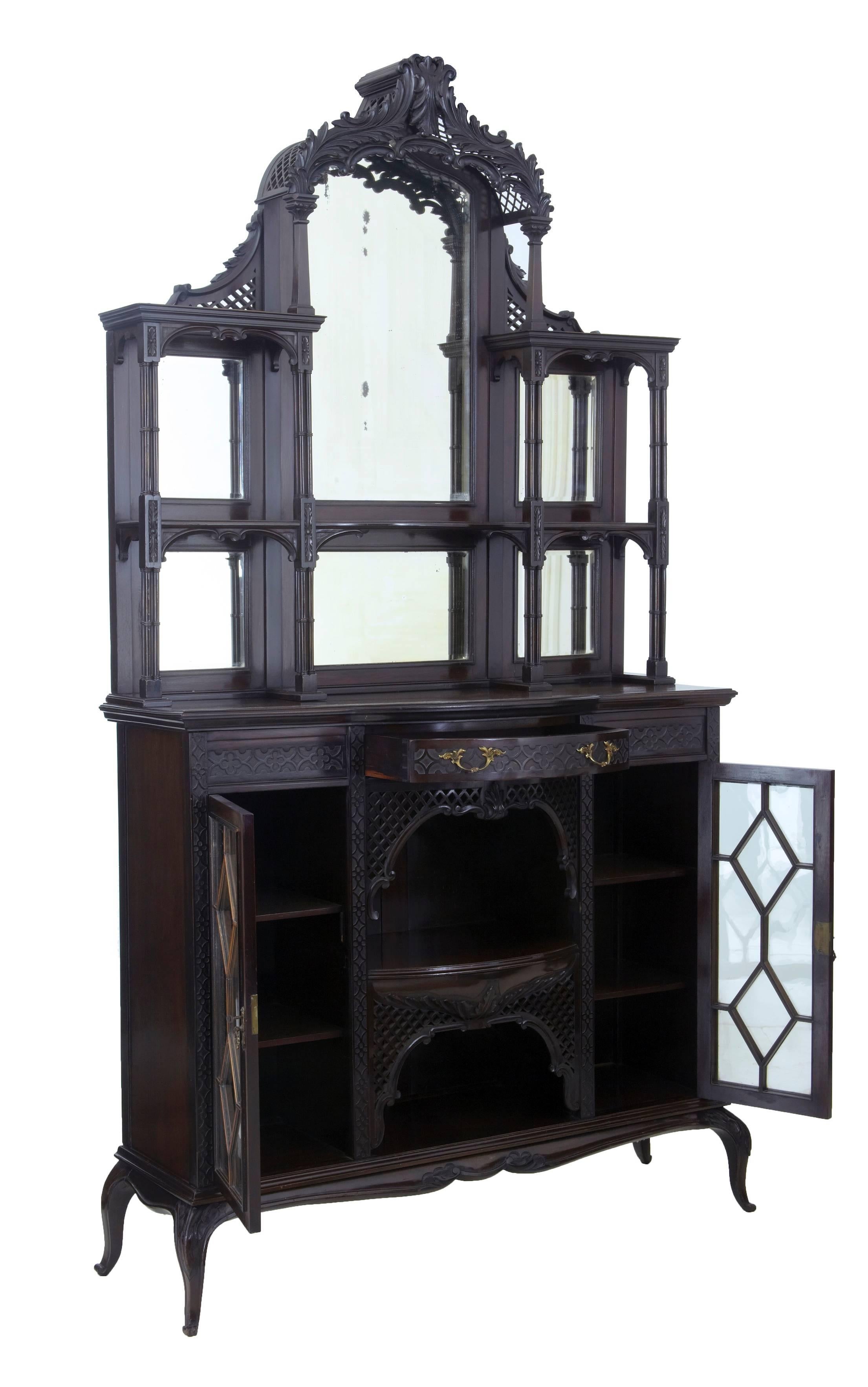 Two part Edwardian mirrored cabinet in the Chippendale taste, circa 1905.
Top section comprising of six mirrors surmounted by carved lattice canopy. Tiers linked together by quad turned columns.
Bottom section of a single drawer with two cupboard