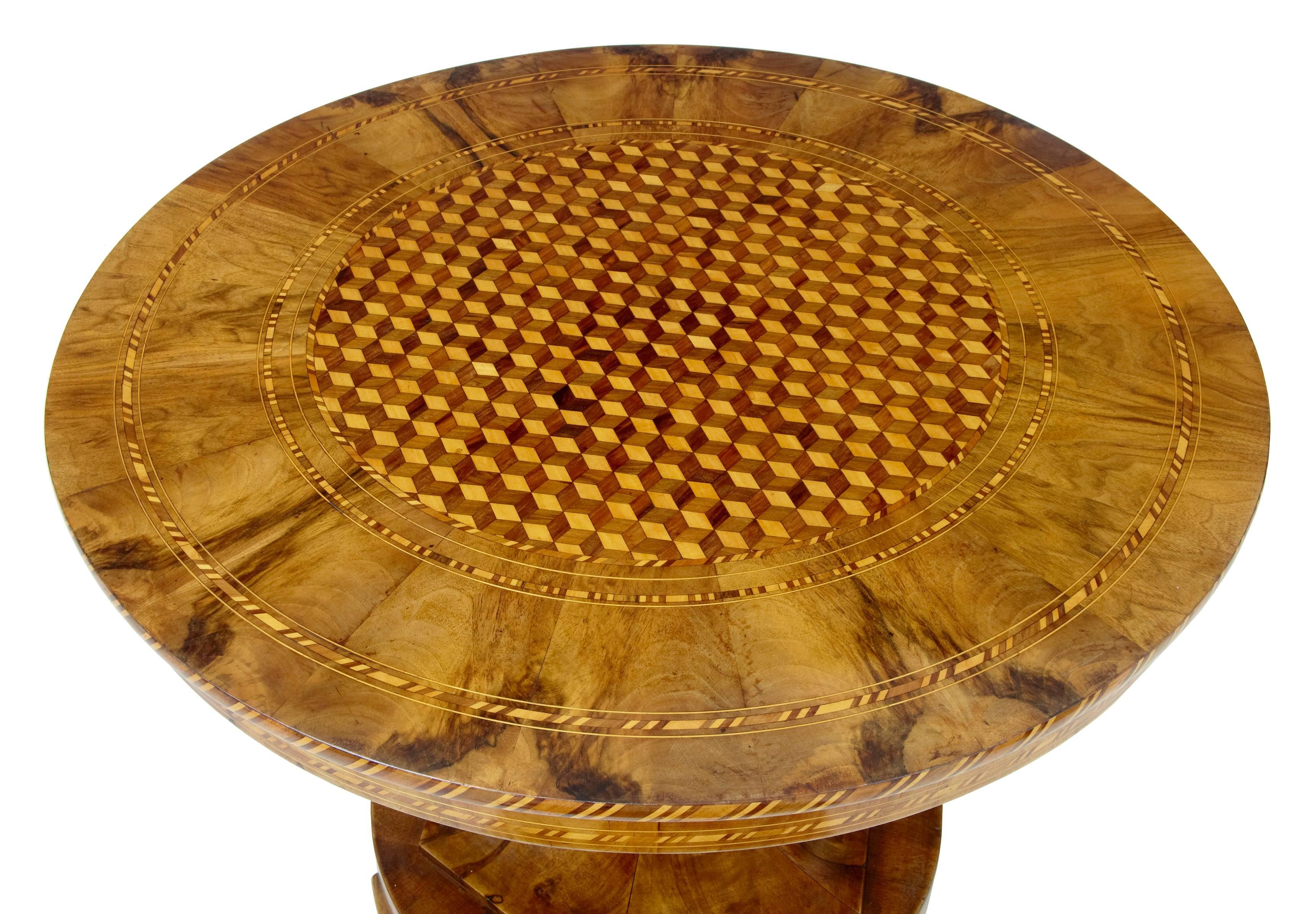 We are pleased to offer you an excellent quality mid-19th century center table, circa 1850.
Beautifully inlaid in the centre with a box M. C. Escher like pattern. Further inlaid with mahogany, satinwood and boxwood.
Standing on a walnut column