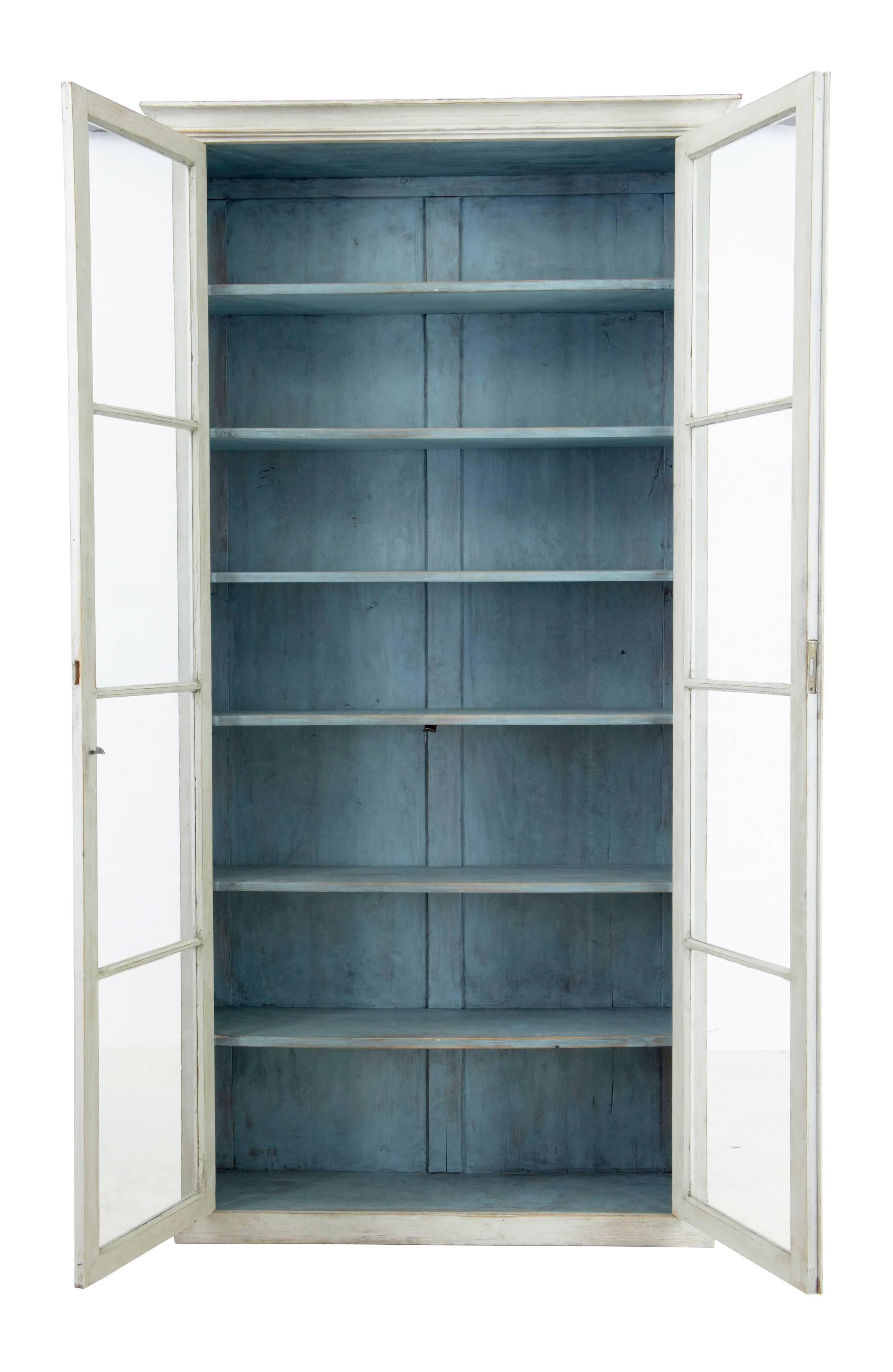 Excellent quality large painted vitrine cabinet, circa 1890.
Pine with later paint which is weathered with slight contrasting faded blue interior.
Original glazed doors.
Six interior shelves.

Measures: Height: 83 1/4