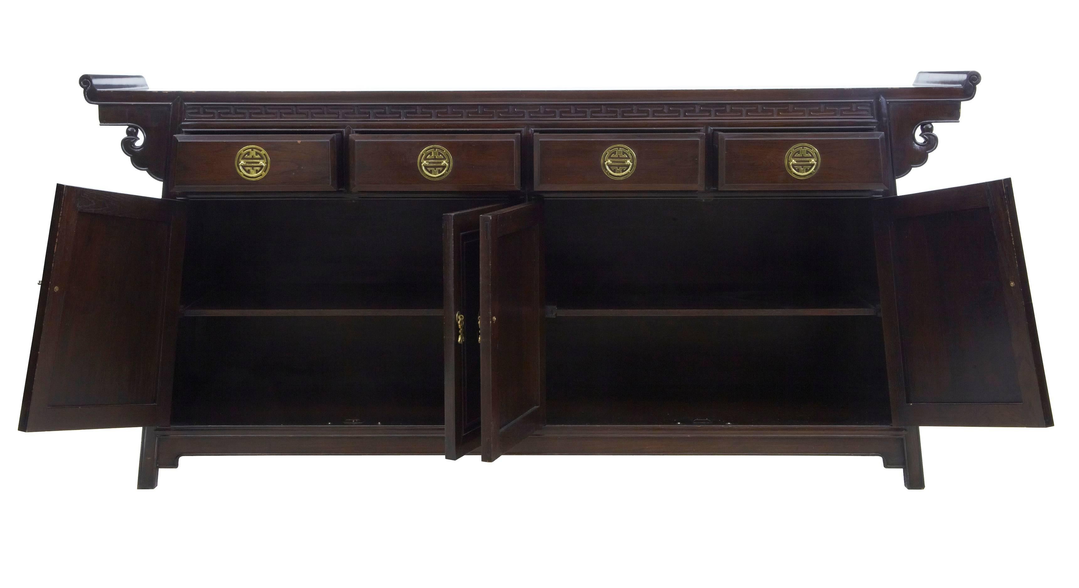 Chinese influenced sideboard, circa 1970.
Typical chinese design, featuring four drawers below which are two double door cupboards each containing one shelf.
Chinese brass hardware.
Light scratches to top and some minor bumps to lacquer