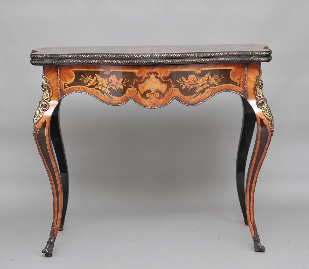 An exhibition quality 19th century free standing French ebonised marquetry and ormolu card table crossbanded in kingwood, the shaped top with ormolu decoration on the edge, profusely inlaid with floral marquetry on the top, the centre of the top