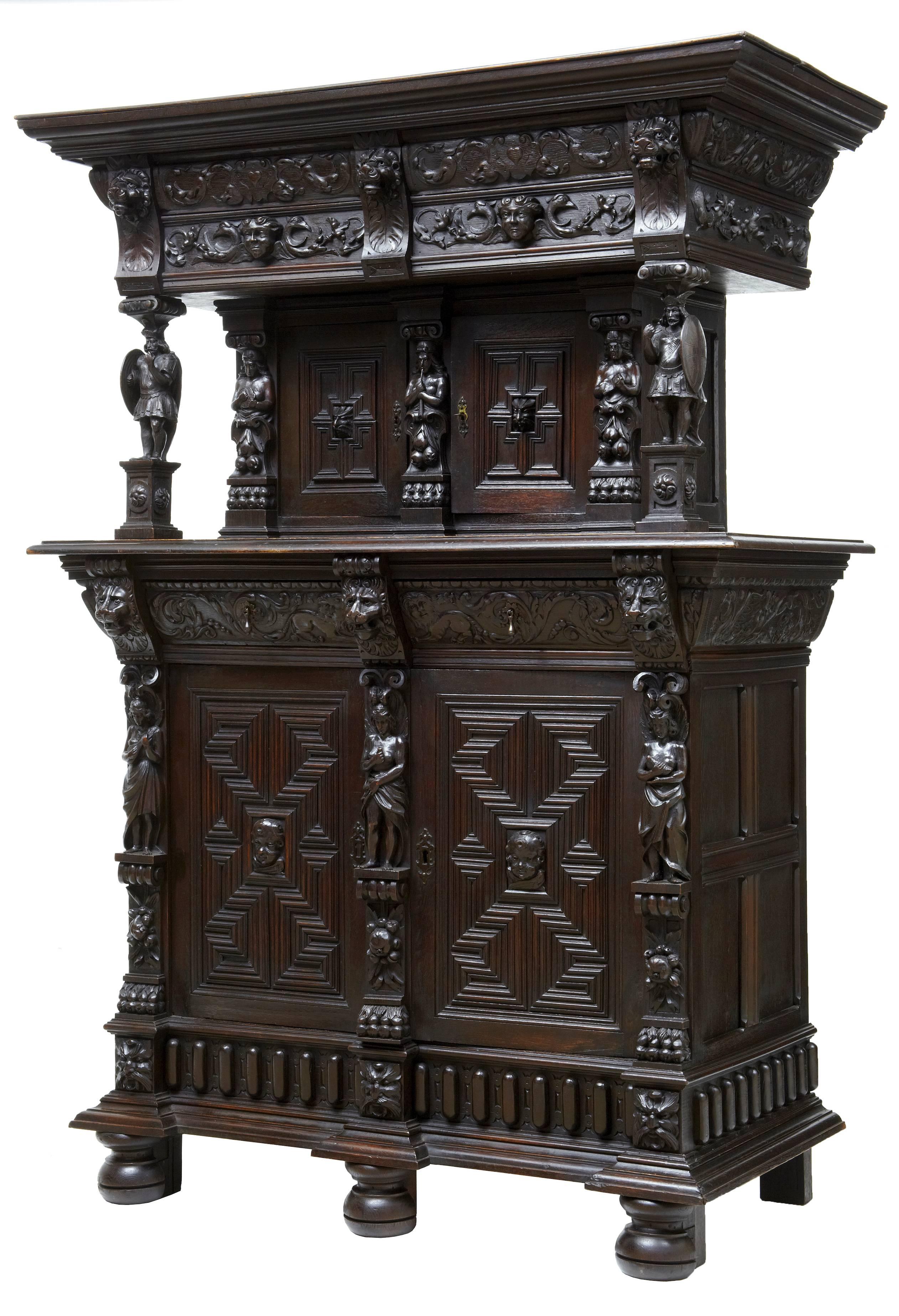 Good quality carved court cupboard, circa 1880.

Small double door cupboard in the top section, followed by two drawers and a larger double door cupboard beneath.

Profusely carved with figures, lion heads, swags and geometric