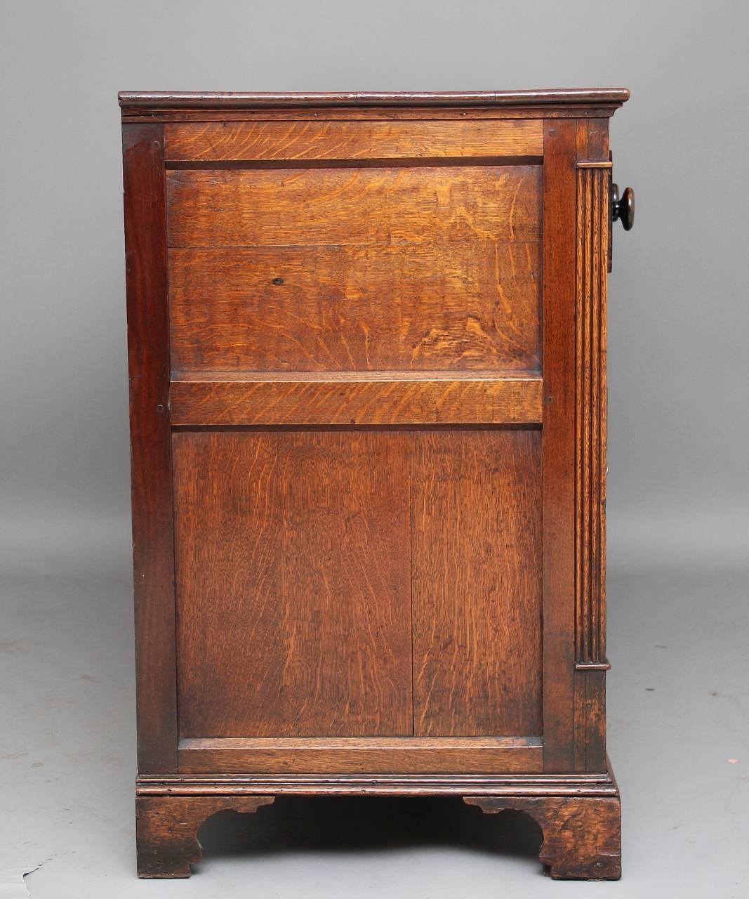 Early 19th century oak cupboard dresser base with an arrangement of six drawers, all with original turned knobs, three drawers along the top and three drawers down the center with a single cupboard either side opening to reveal a single shelf