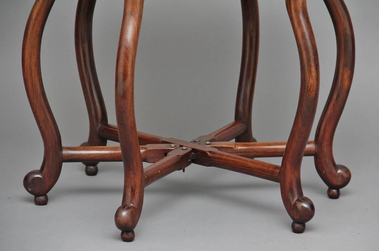 19th century Chinese rosewood occasional table with a circular dish shaped top supported on a folding base with six elegant shaped legs, circa 1880.

Measures: Height: 21