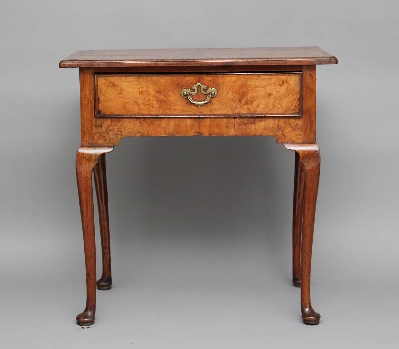 18th century elm lowboy with a quartered veneered moulded edge elm top with walnut crossbanding with a single oak lined drawer with original handle, standing on cabriole legs terminating with pad feet, circa 1760.

Measures: Height: 28
