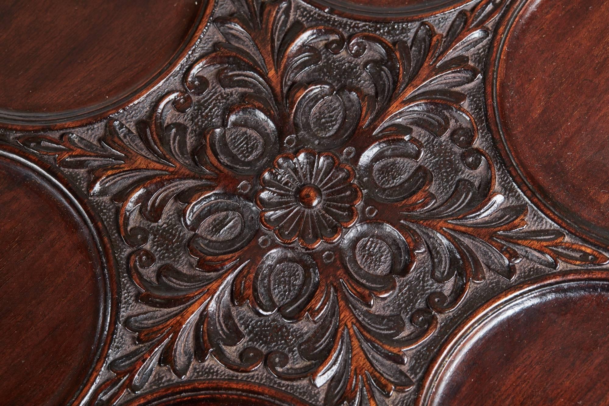 Good quality carved mahogany two-tier revolving dumb waiter, with a dish top, carved pie crust edge, supported by a carved reeded column, the lower tier with a carved pie crust edge supported by a carved reeded column standing shaped carved ball and