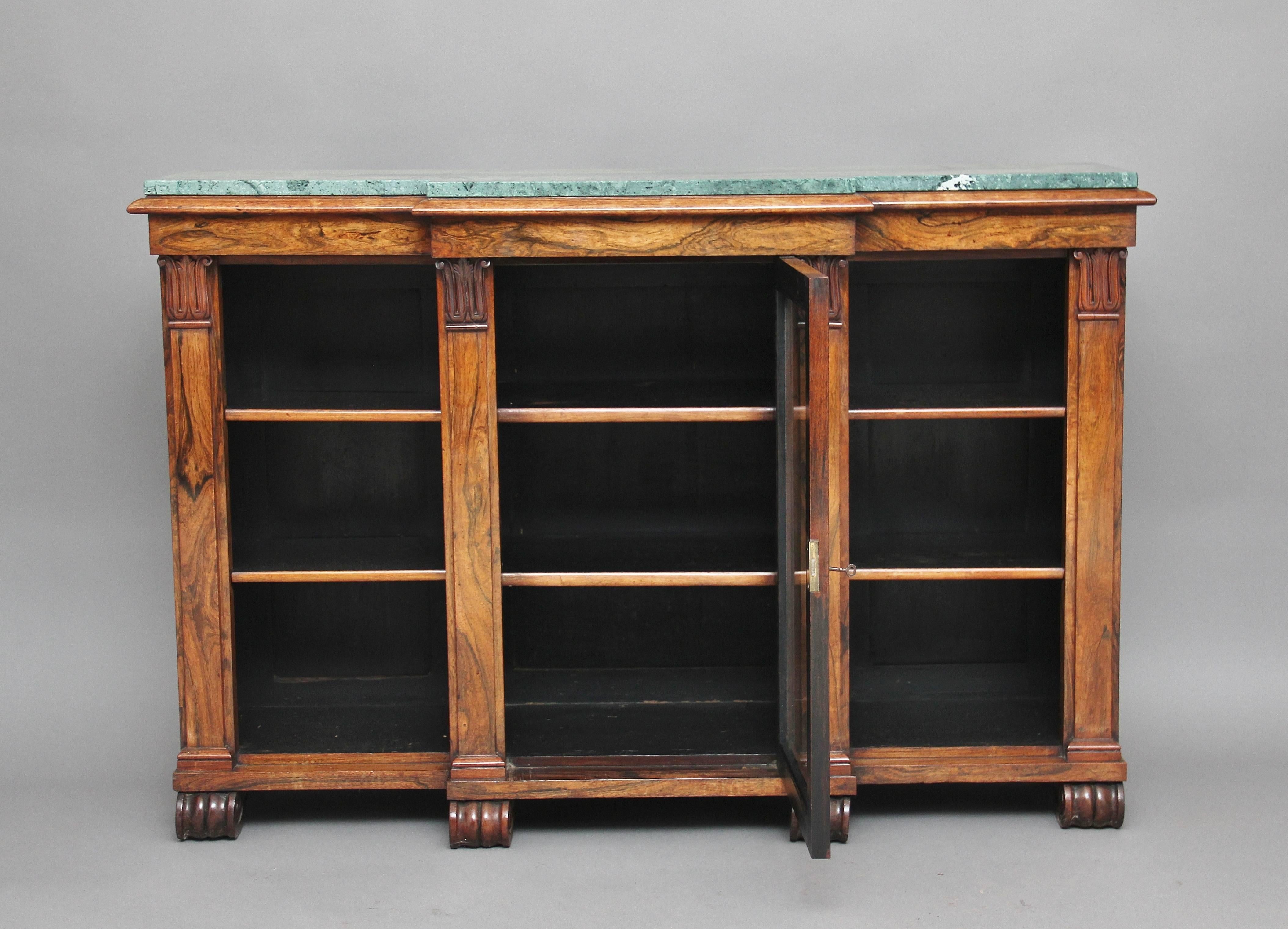 19th century rosewood breakfront bookcase or cabinet with a turquoise marble top, with a frieze below with a nice moulded edge, the cabinet having a glazed central door flanked either side by open shelves, with two shelves in each of the three