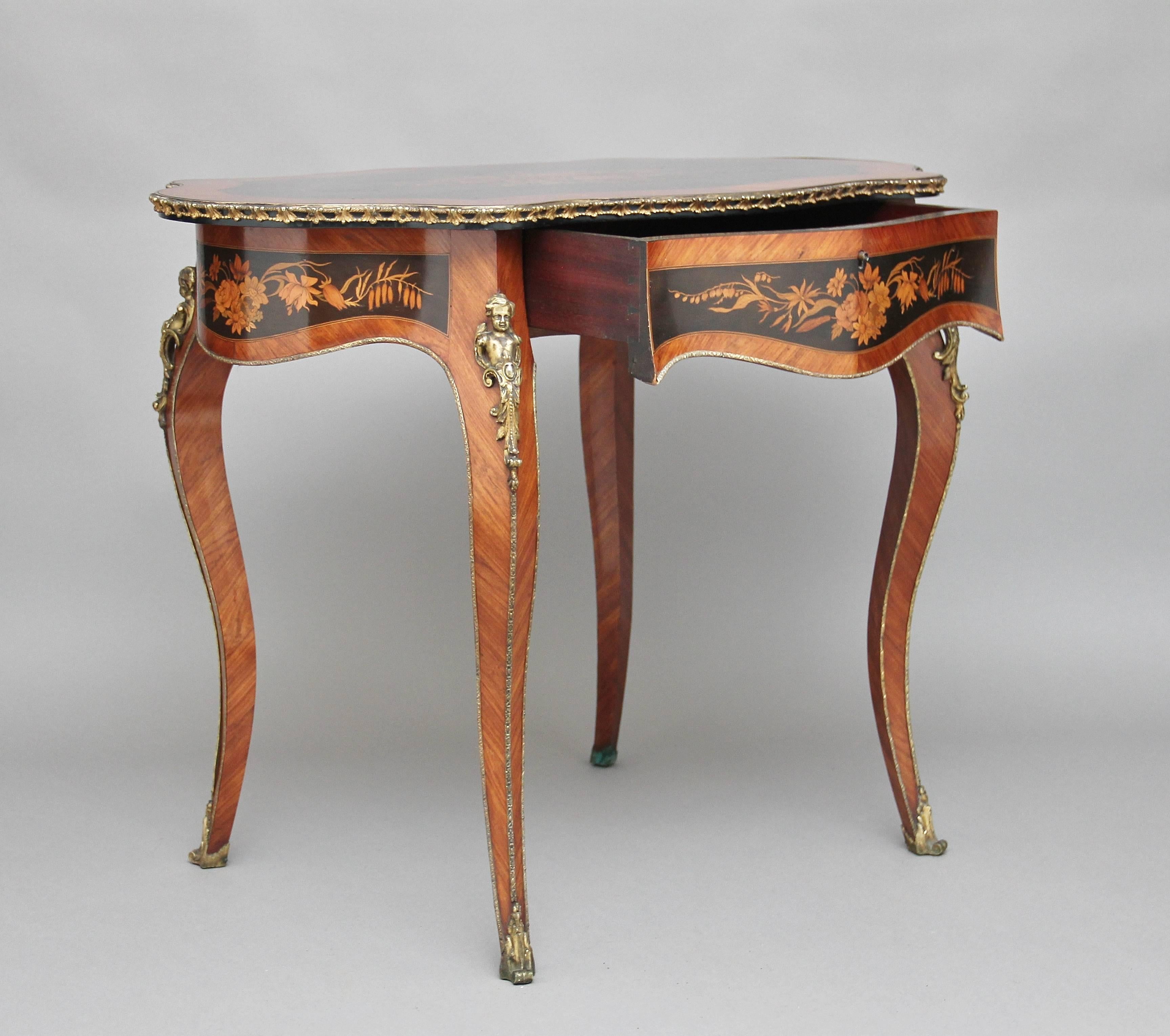 19th century French kingwood freestanding inlaid and ormolu mounted center or side table, the shaped top with ormolu decoration running along the edge, the center of the top inlaid with floral marquetry on an ebonized background, with a shaped