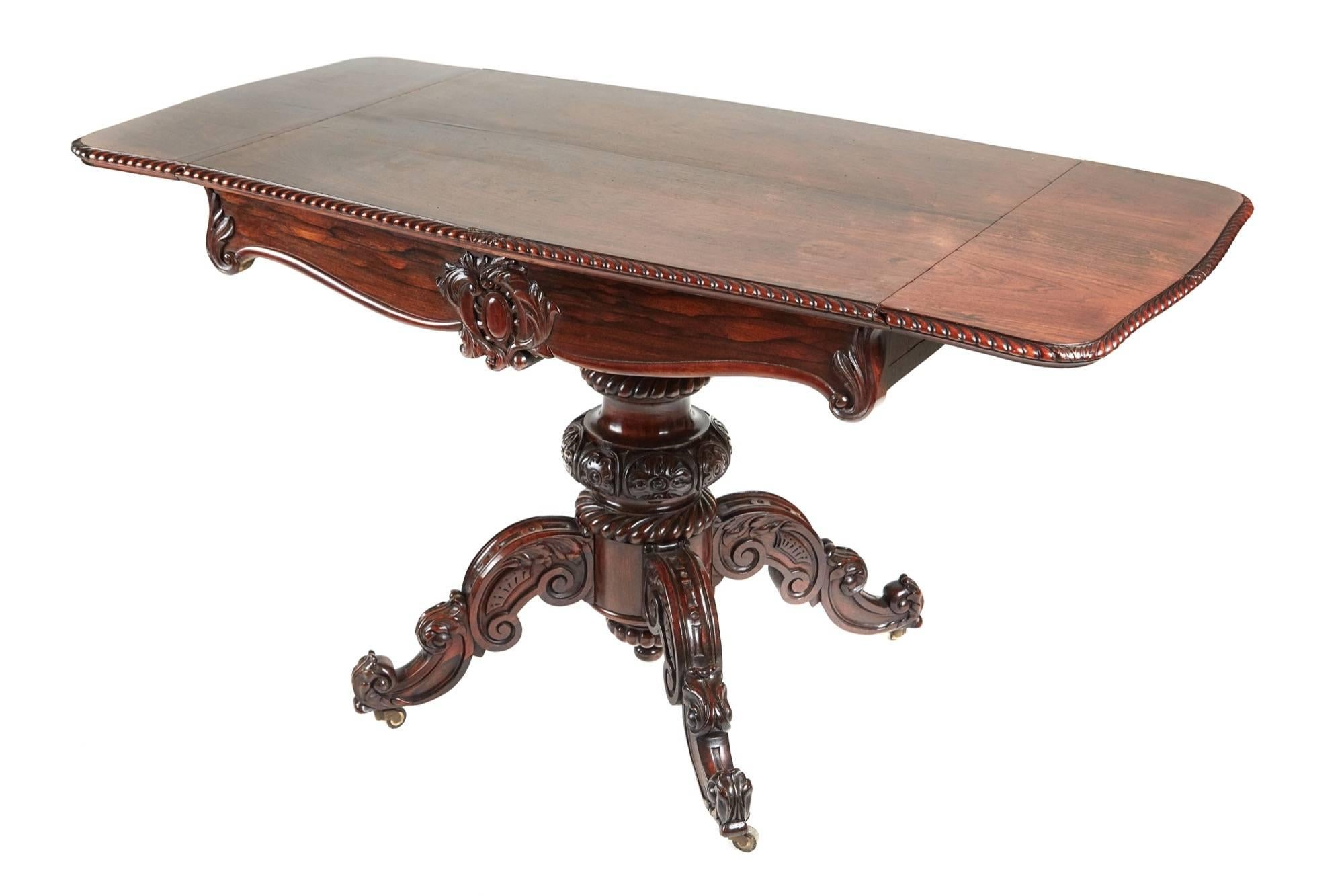 Outstanding Victorian carved rosewood sofa table, wonderful color and a lovely carved gadrooned edge detail to the top with two drop leaves, the frieze is fitted with one long carved drawer, supported by a fantastic carved solid rosewood column,