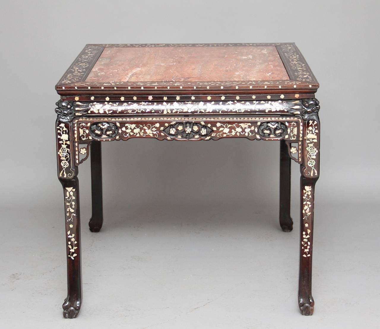 19th century Chinese carved rosewood centre table profusely inlaid with mother-of-pearl, with a pink marble top, with pierced fret along the sides, standing on ball and claw feet, circa 1880.
Minor losses and restorations.

Measuress: Height: