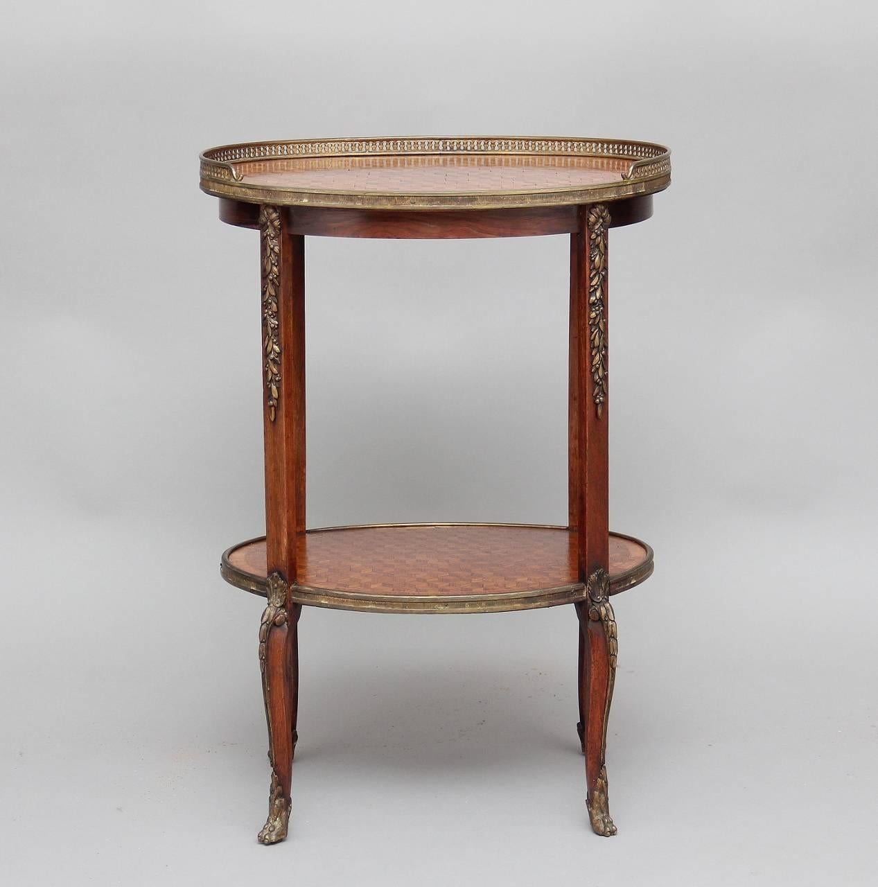 19th century French kingwood and parquetry etagere, with a parquetry top and shelf, the top having a three quarter brass gallery, with four supports decorated with brass mounts, standing on shaped slender legs decorated also with brass mounts, circa
