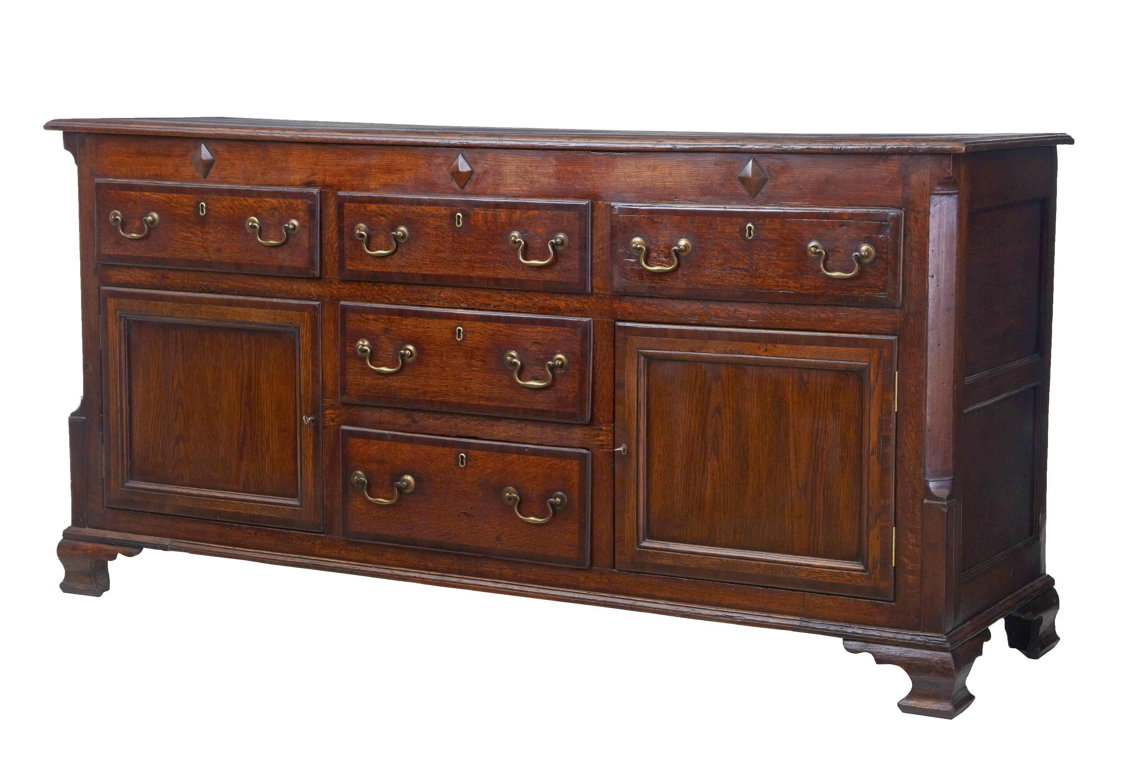 Good quality oak dresser base, circa 1780.
Three drawers over two drawers and two cupboards.
Crossbanded drawer fronts.
Canted corners, standing on original bracket feet.

Measures: Height 35 1/2",
length 72 1/4",
depth 21".
 