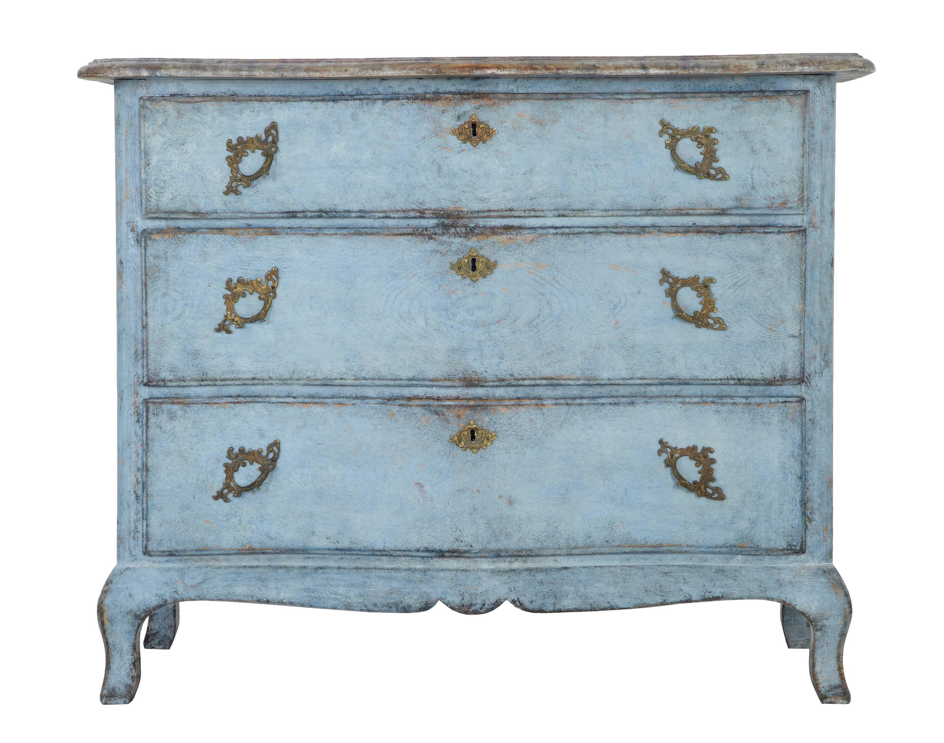 Three-drawer serpentine shaped Swedish commode in later blue paint and faux marble top, circa 1880.
Weathered paint which shows the grain in the pine drawer fronts.
Ornate handles and escutheons.

Measures: Height 32