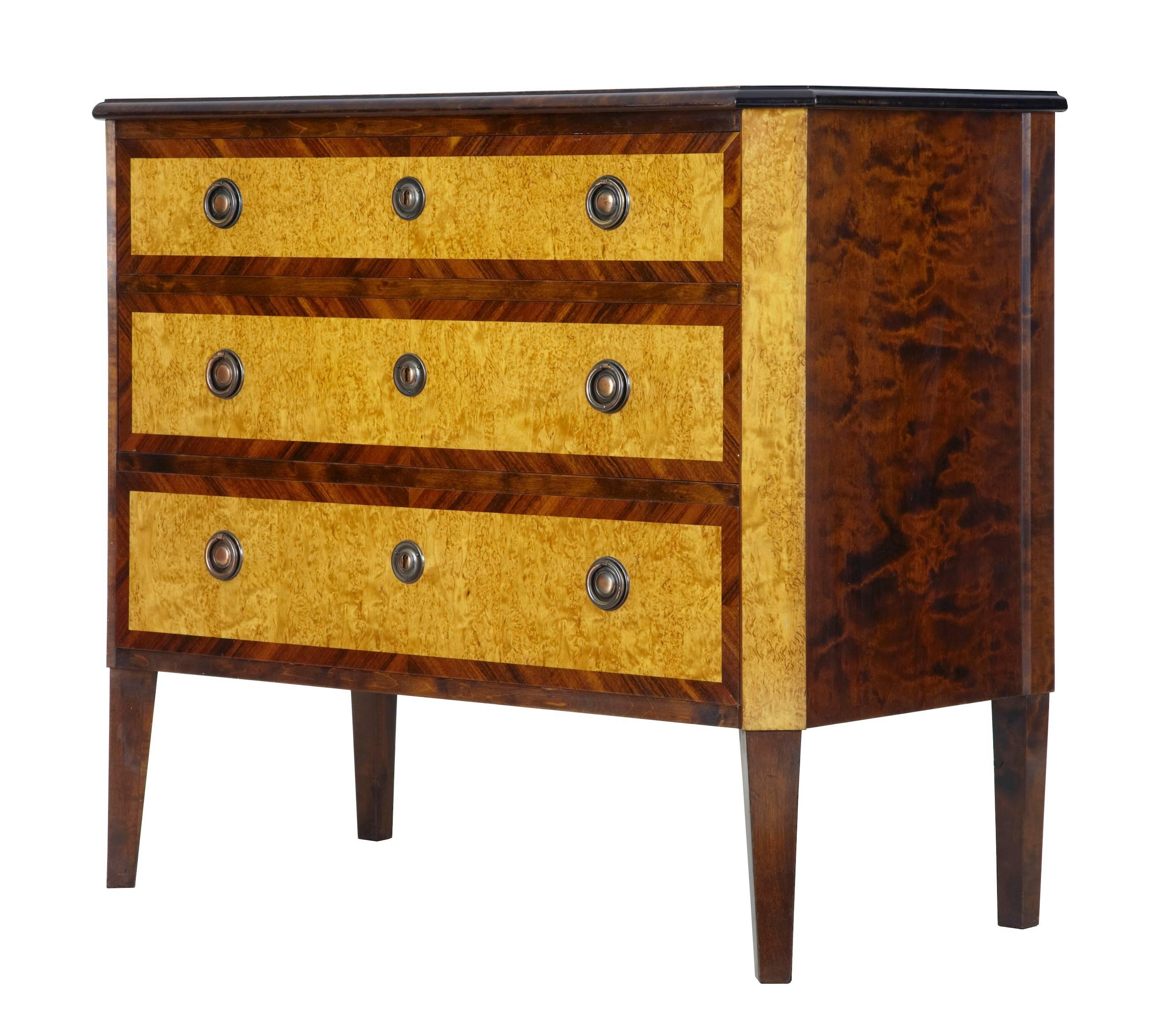 Birch commode crossbanded with kingwood, circa 1920.
Three-drawer chest, with contrasting veneers. Dark birch top.
Standing on tapering legs.
Some marking to top surface.

Measures: Height 32 1/2