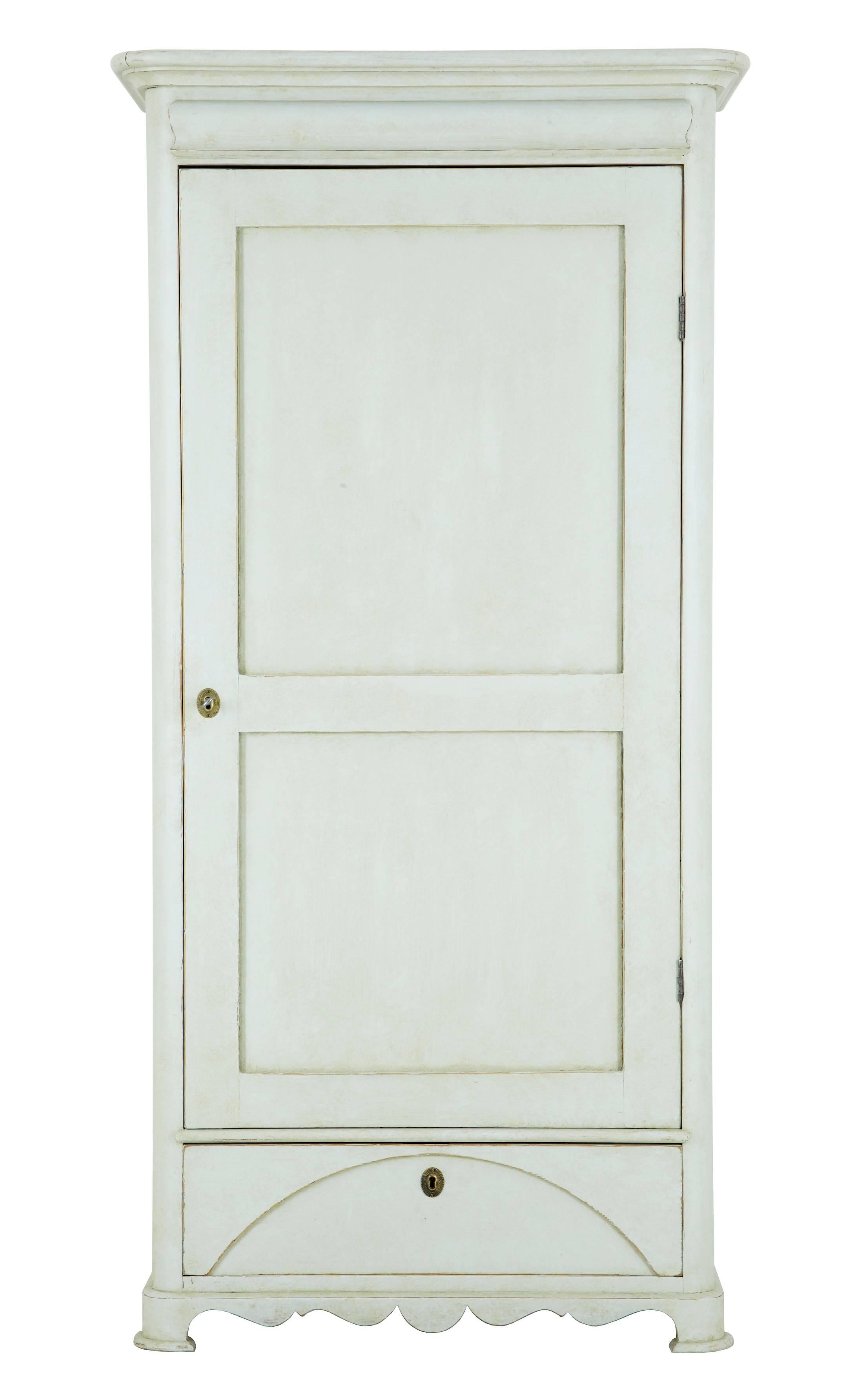 Delightful small Swedish cupboard cabinet, circa 1890.
Off white lemon colored later paint, with bare pine interior.
Single door opens to three shelves below which is a single drawer.

Measures: Height: 70