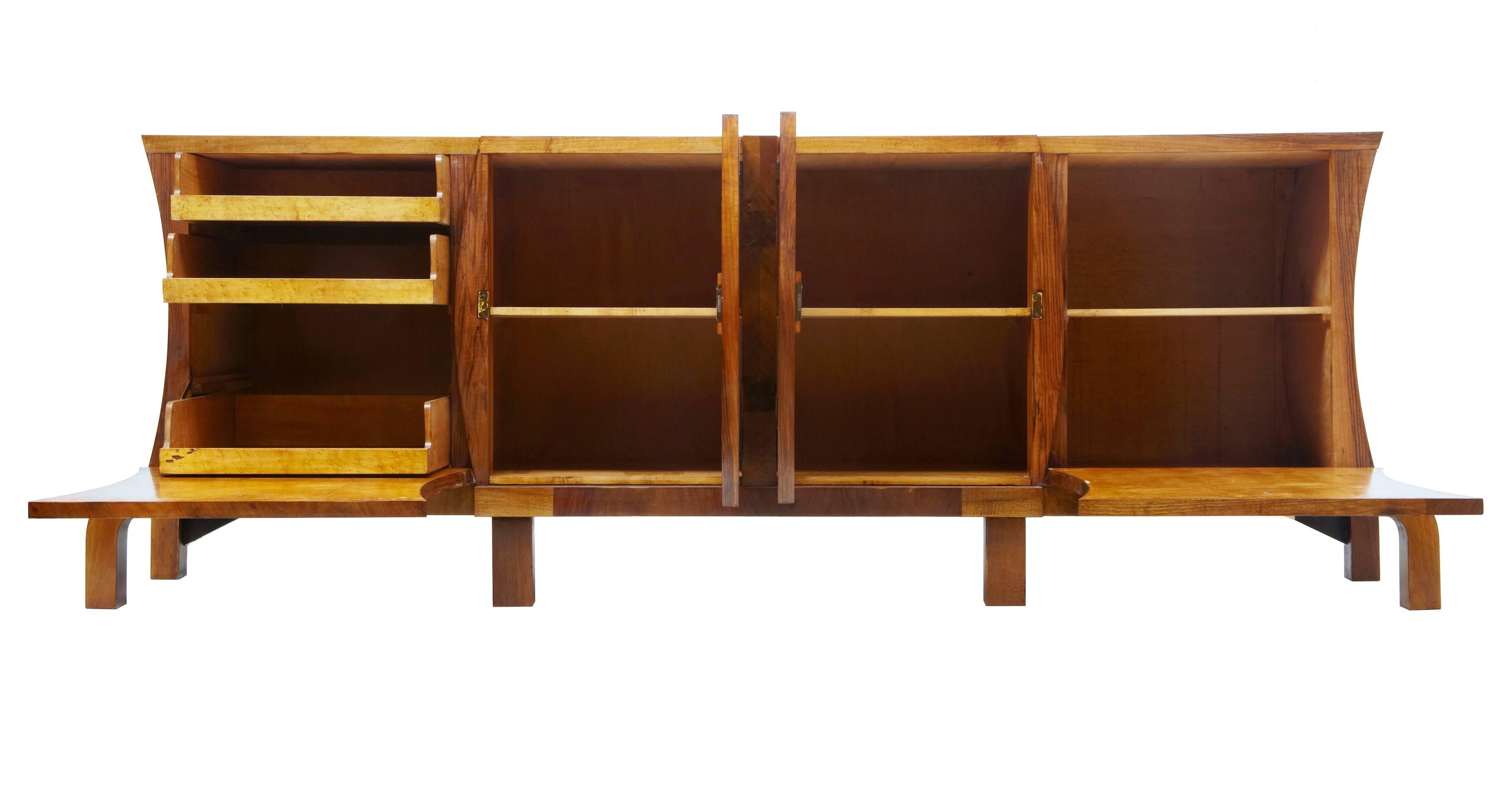 Imposing Art Deco sideboard of large proportions, circa 1920.
Beautiful veneered in walnut and beautifully crossbanded in burr walnut.
Two central doors that open to a single shelf in each, flanked either side by a drop down door front. Containing
