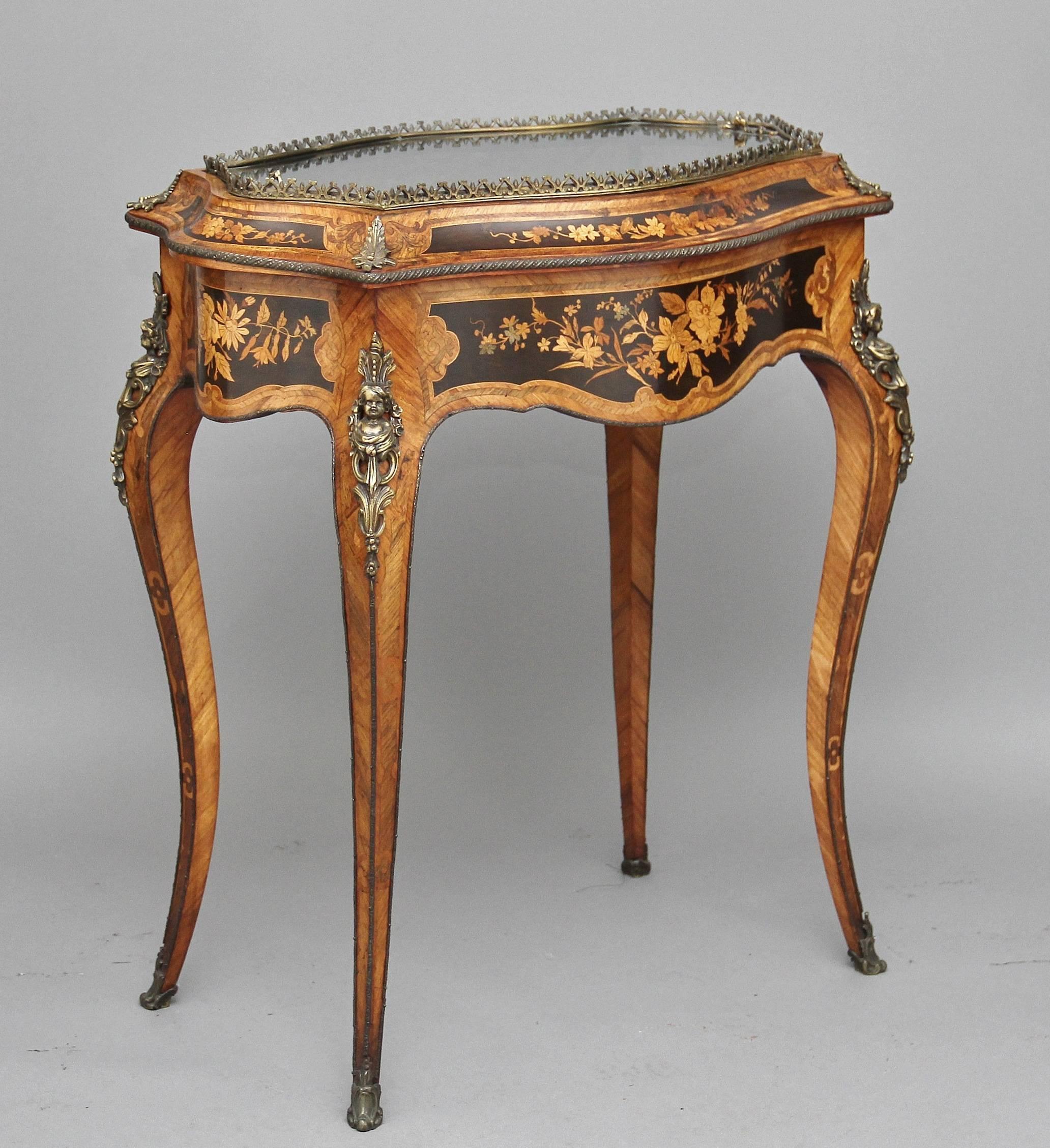 19th century French kingwood and inlaid bijouterie table with lovely quality gilt mounts, with a brass gallery mount surrounding a removable glass panel top enclosing a lined interior, having a shaped apron on all sides decorated with floral