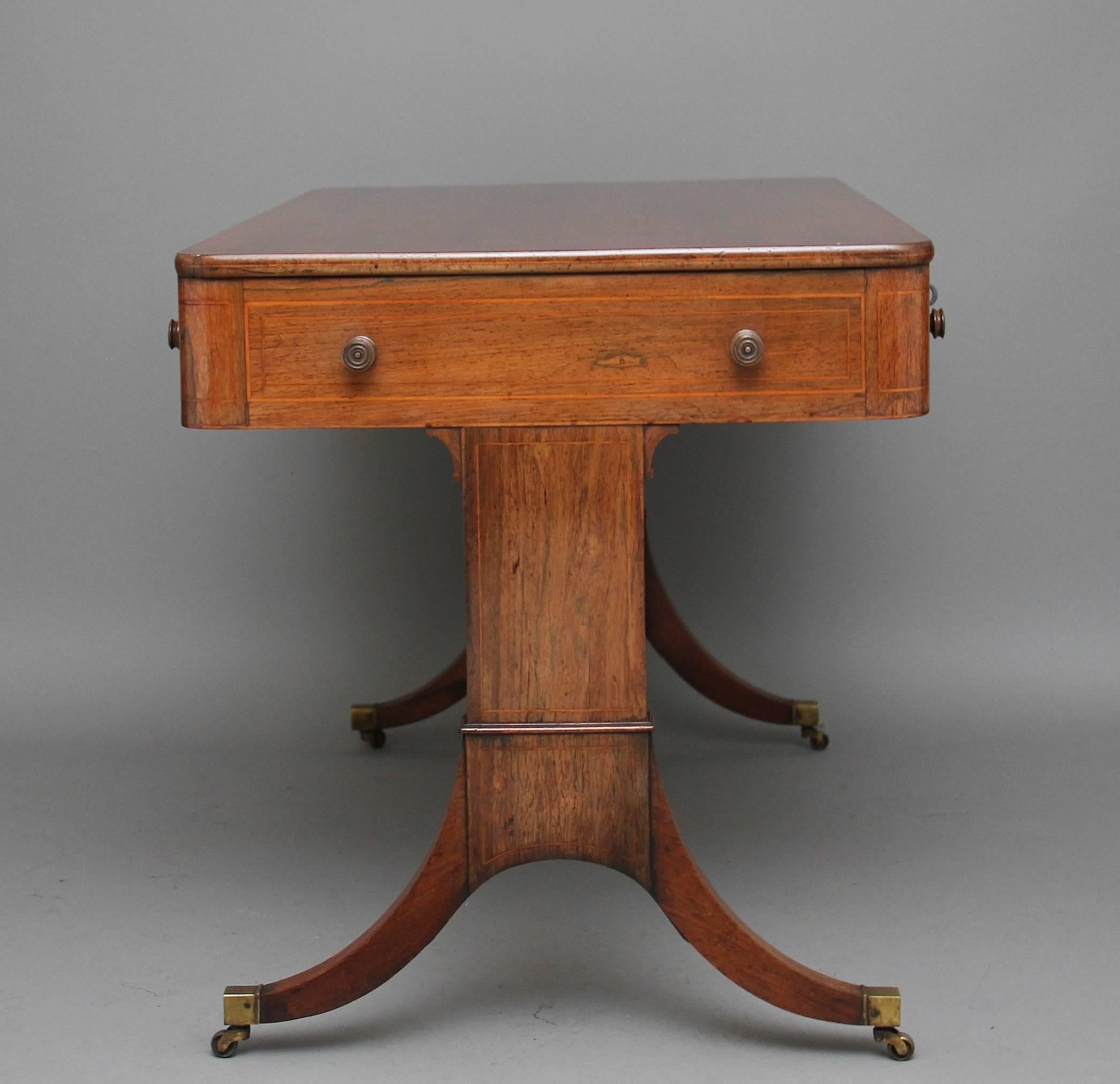 19th century rosewood inlaid writing or sofa table, the rounded rectangular top above two mahogany lined drawers with original wooden turned knobs, the reverse the same but having dummy drawers, the sides of the table decorated also with original