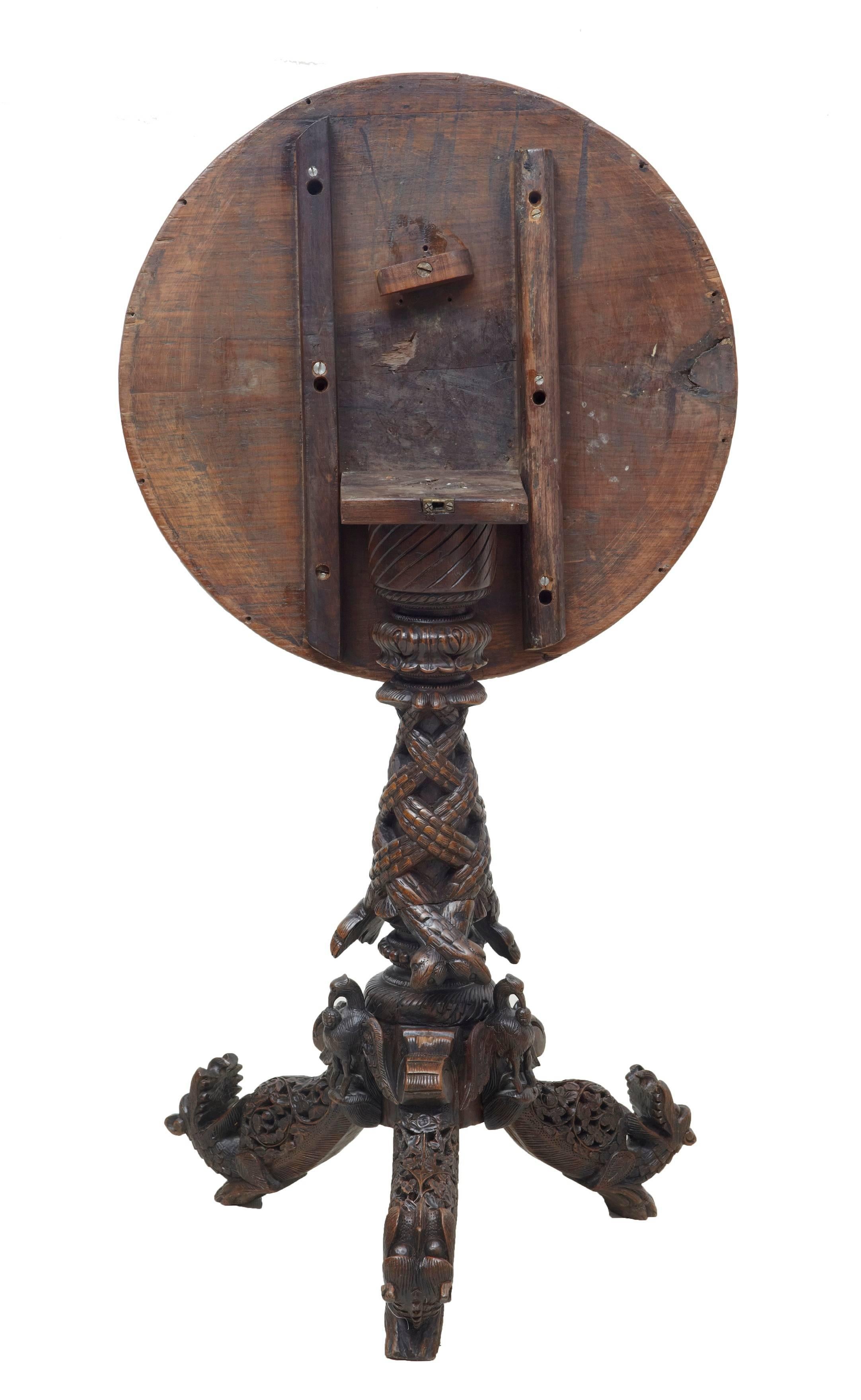 Good quality burmese or Anglo Indian tilt top table, circa 1880.
Carved top with birds, foliage and architecture. Tilt top which leads down to the carved tripod base.
Carved birds and dogs adorn the feet.
Age splits to top which haven't gone all