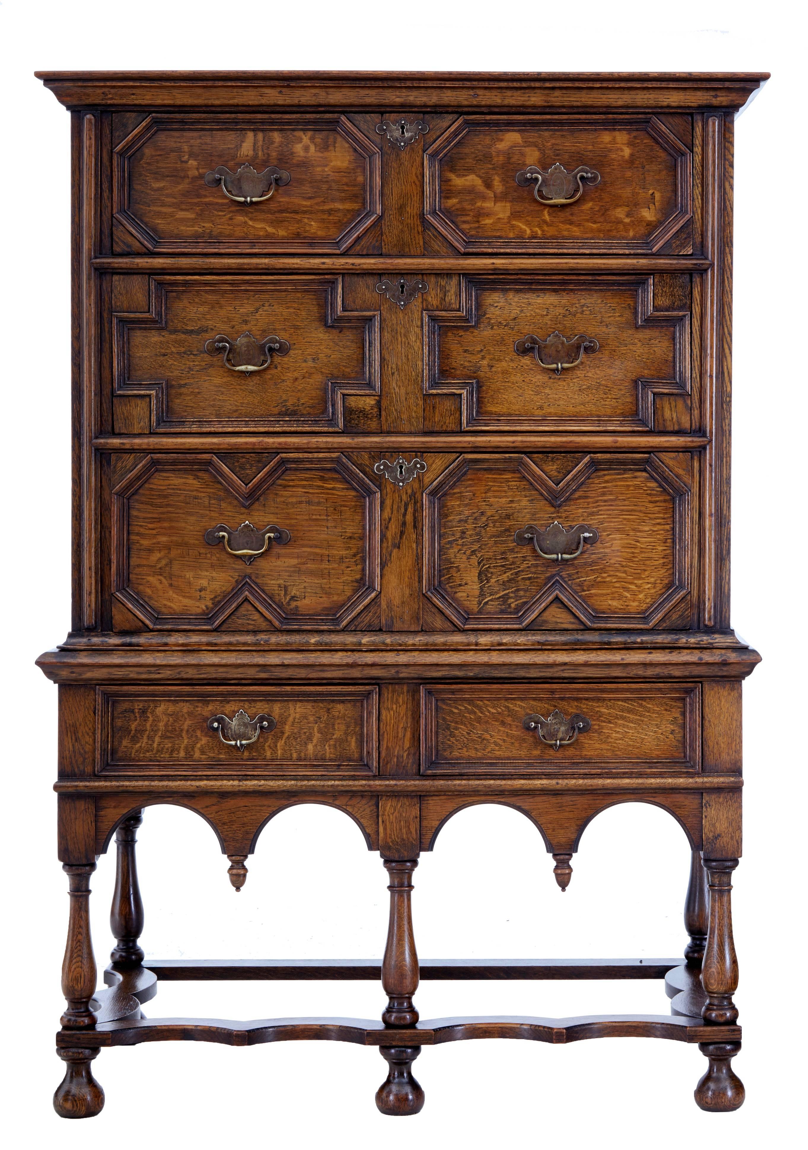 Oak chest on stand in the Jacobean taste, circa 1950.
Splits into two sections. The top section with three graduating drawers with geometric moulded fronts.
Bottom section with two further drawers. Standing on six turned legs united by shaped