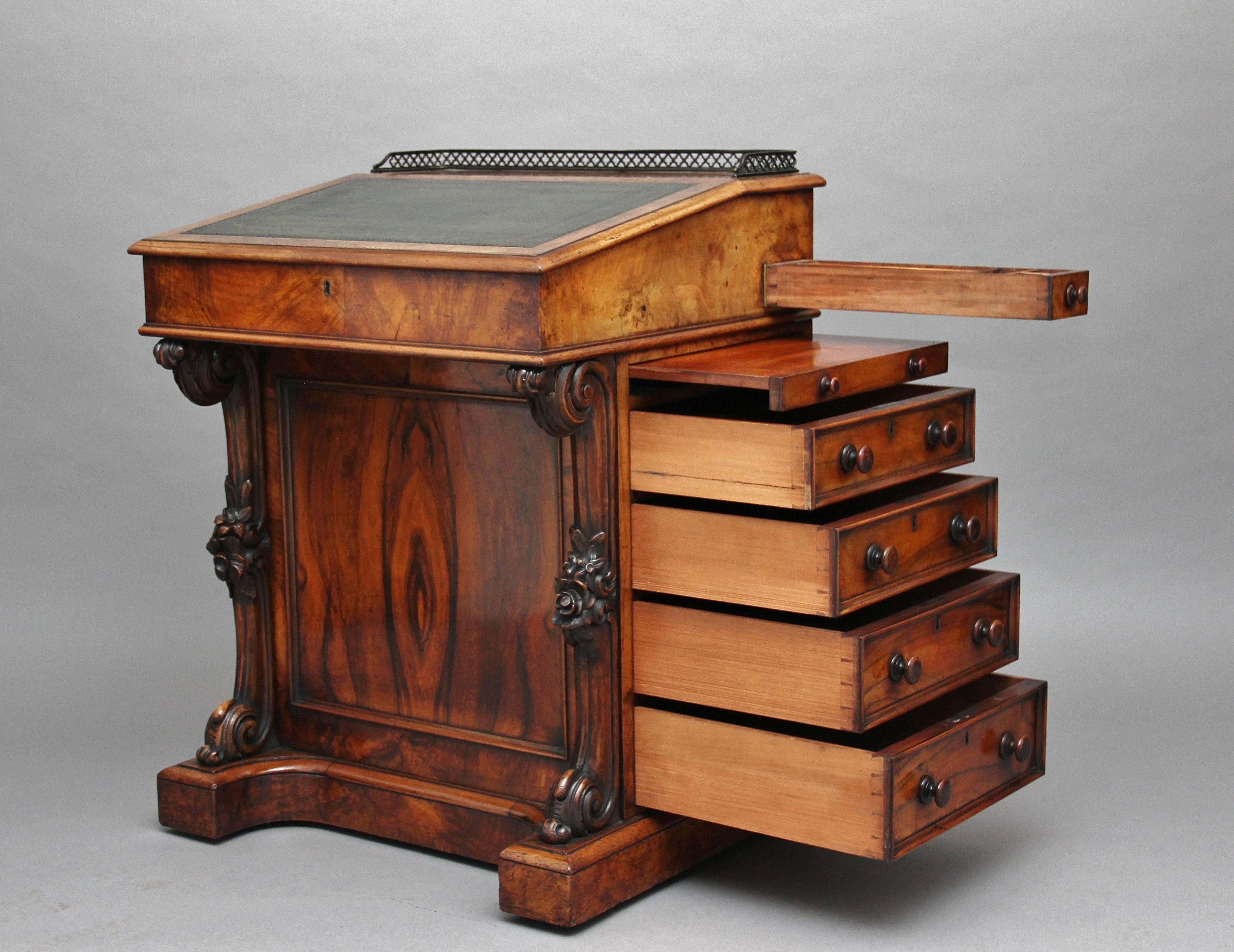 19th century walnut Davenport writing desk, the slide action top with a green leather writing surface decorated with gold tooling, surmounted by a pierced brass gallery, the hinged sloping lid opening to reveal an interior with two drawers at the