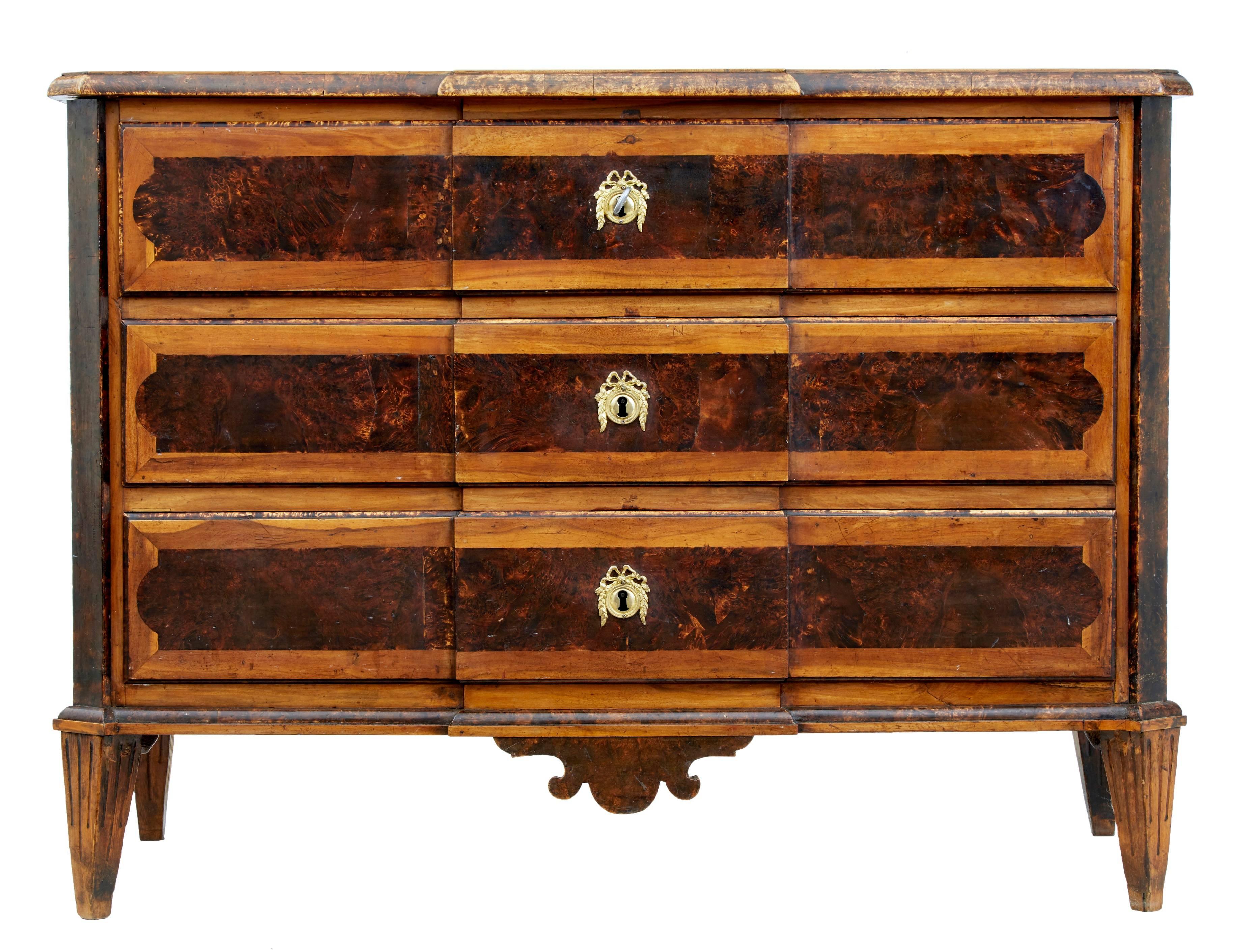 Rare piece of 19th century Swedish furniture, circa 1860.
Three drawer commode in birch and contrasting alder root veneers.
Original color and patina.
Drawers open on the key.
Standing on fluted tapering legs.

Measures: Height 31 1/4