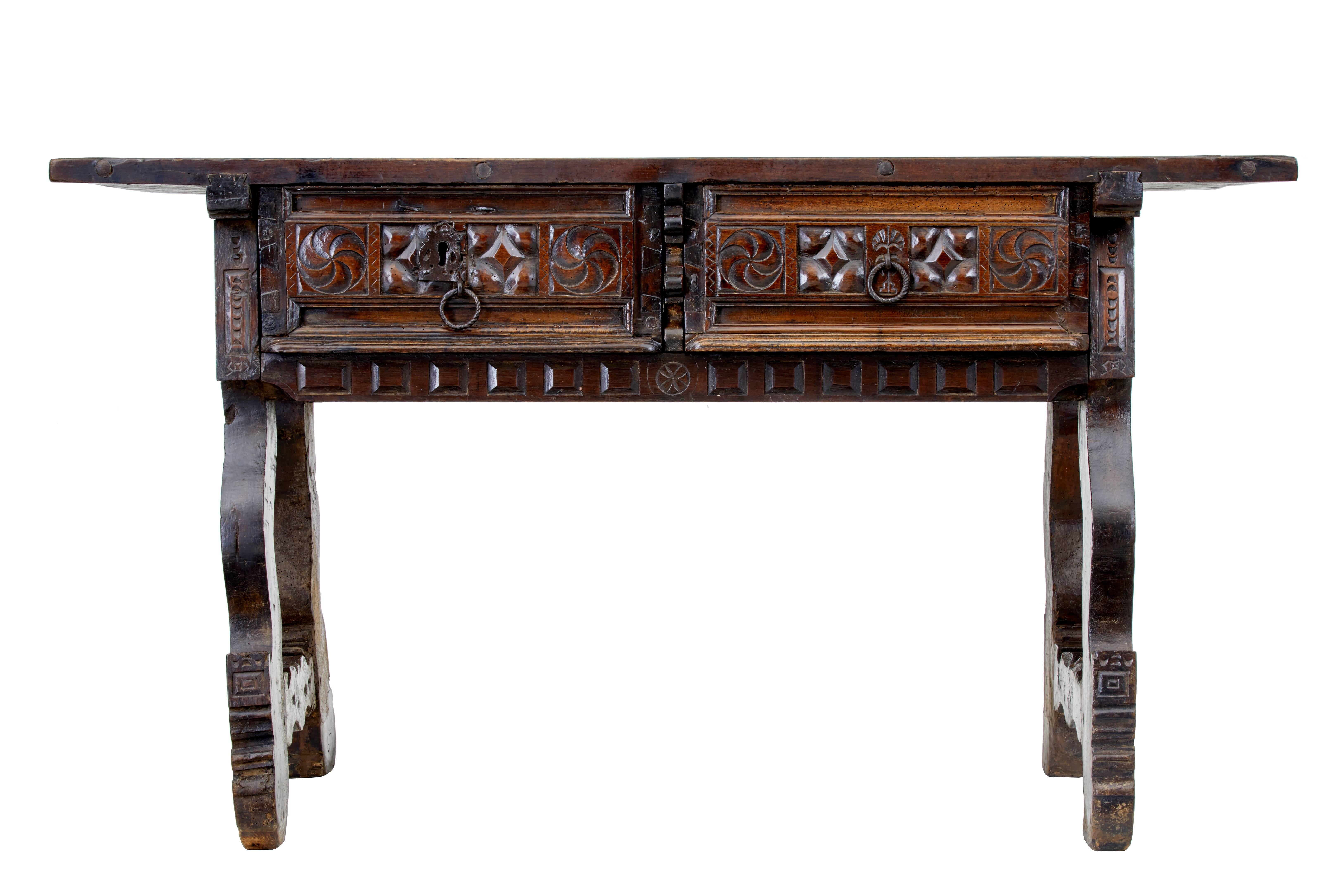 Good quality 17th century Spanish table, circa 1680.
Two drawers heavily carved with original hardware (no key)

Solid walnut top with expected shrinkage and areas of fill.
Stunning original color and patina.
Standing on typical trestle end