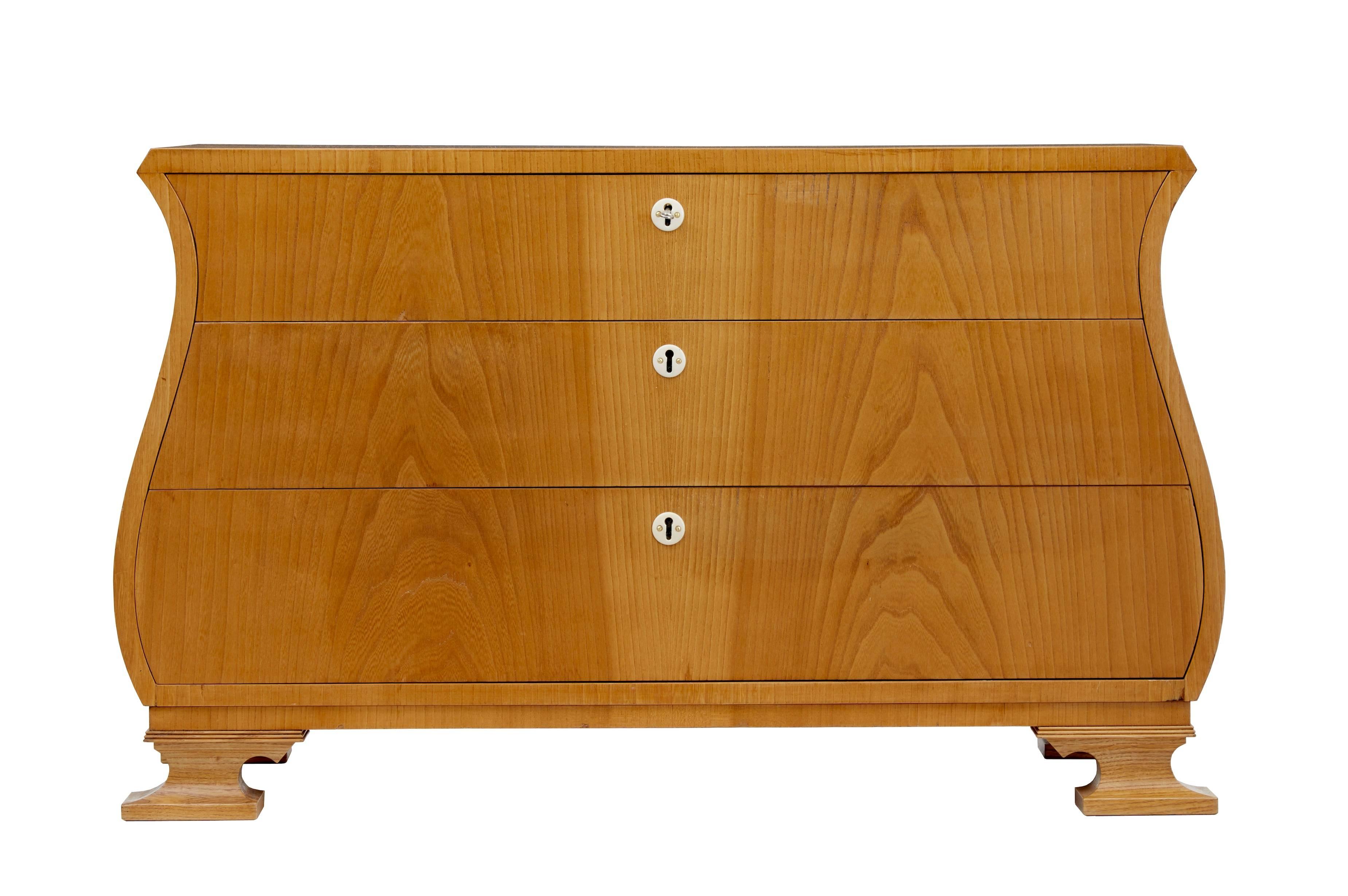 Rare elm veneered chest of drawers, circa 1950.
Three drawers that open on the key.
Desirable lyre shape, standing on sledge feet.
Minor surface marks and repairs to veneer.

Measures: Height 24 3/4"
width 40 1/2"
depth 16