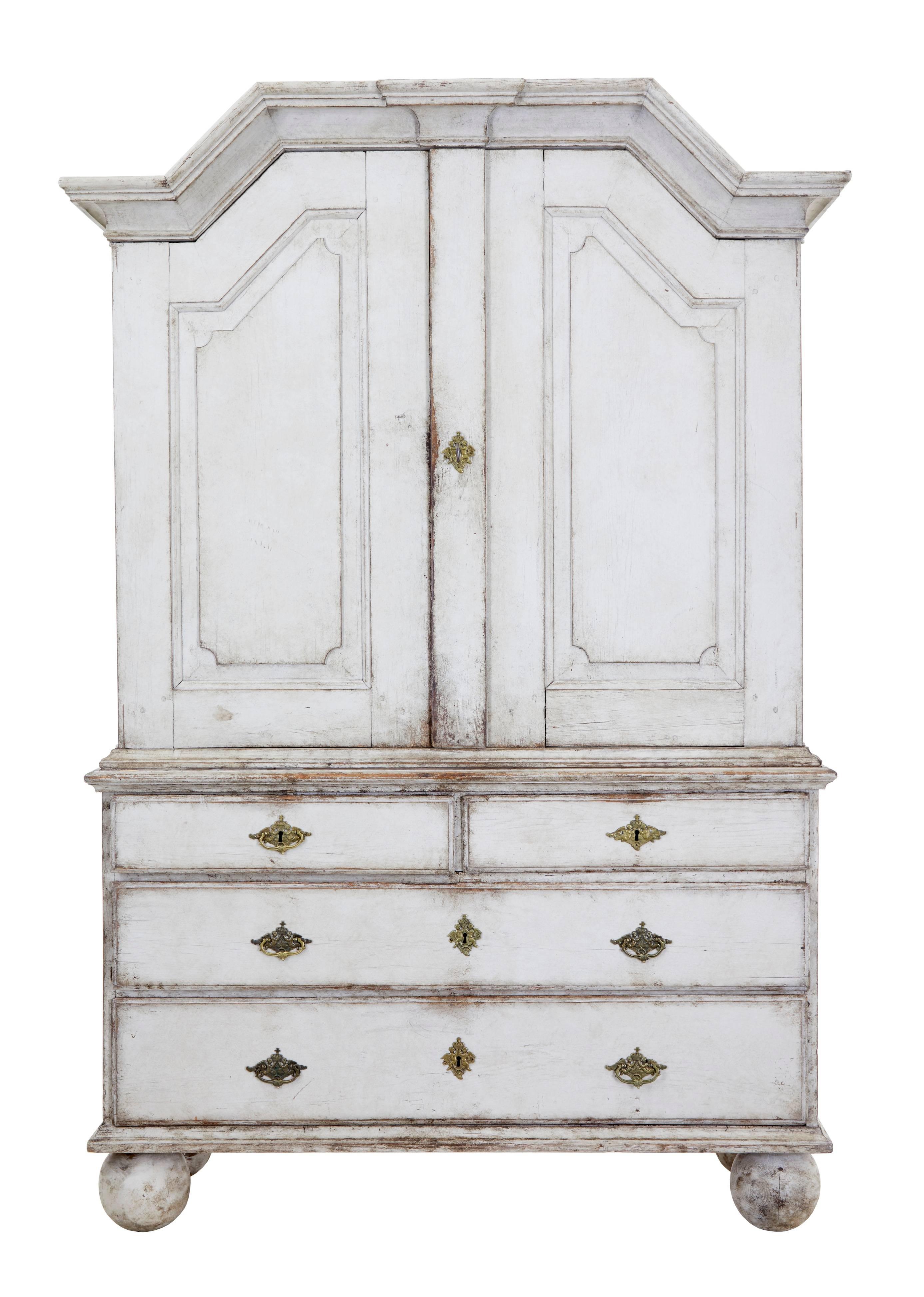 Fine architectural Swedish pine cabinet on chest, circa 1850.
Consisting of two parts.
Top section with architectural cornice. Double doors open to reveal four shelves.
Bottom chest section with two short over two long drawers. Standing on