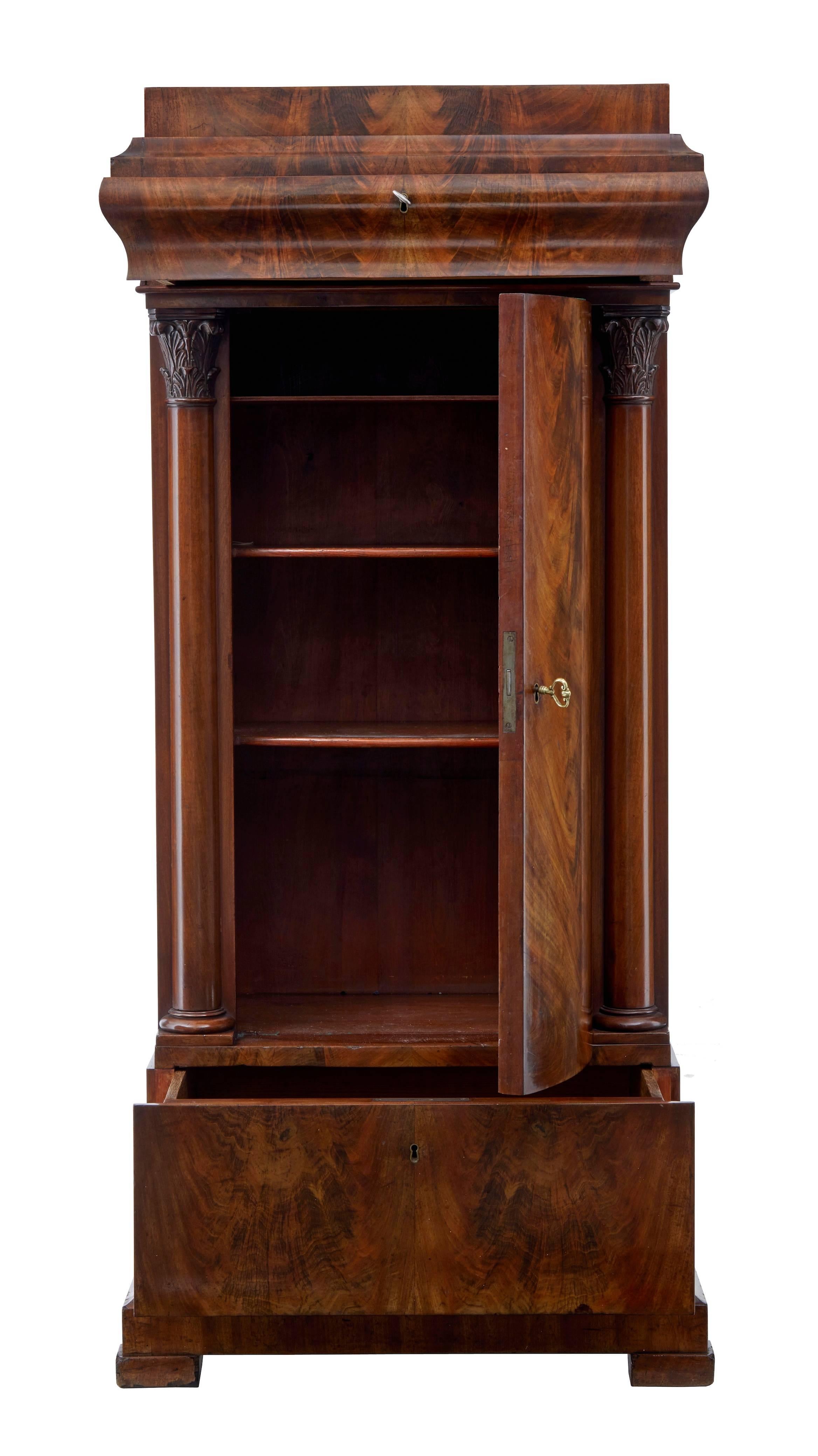 Fine quality Biedermeier cabinet, circa 1860.
Made from fine quality flame mahogany veneers.
Single shaped door that opens to three shelves, flanked either side by carved Corinthian columns. Above which is a single drawer completed with a deep