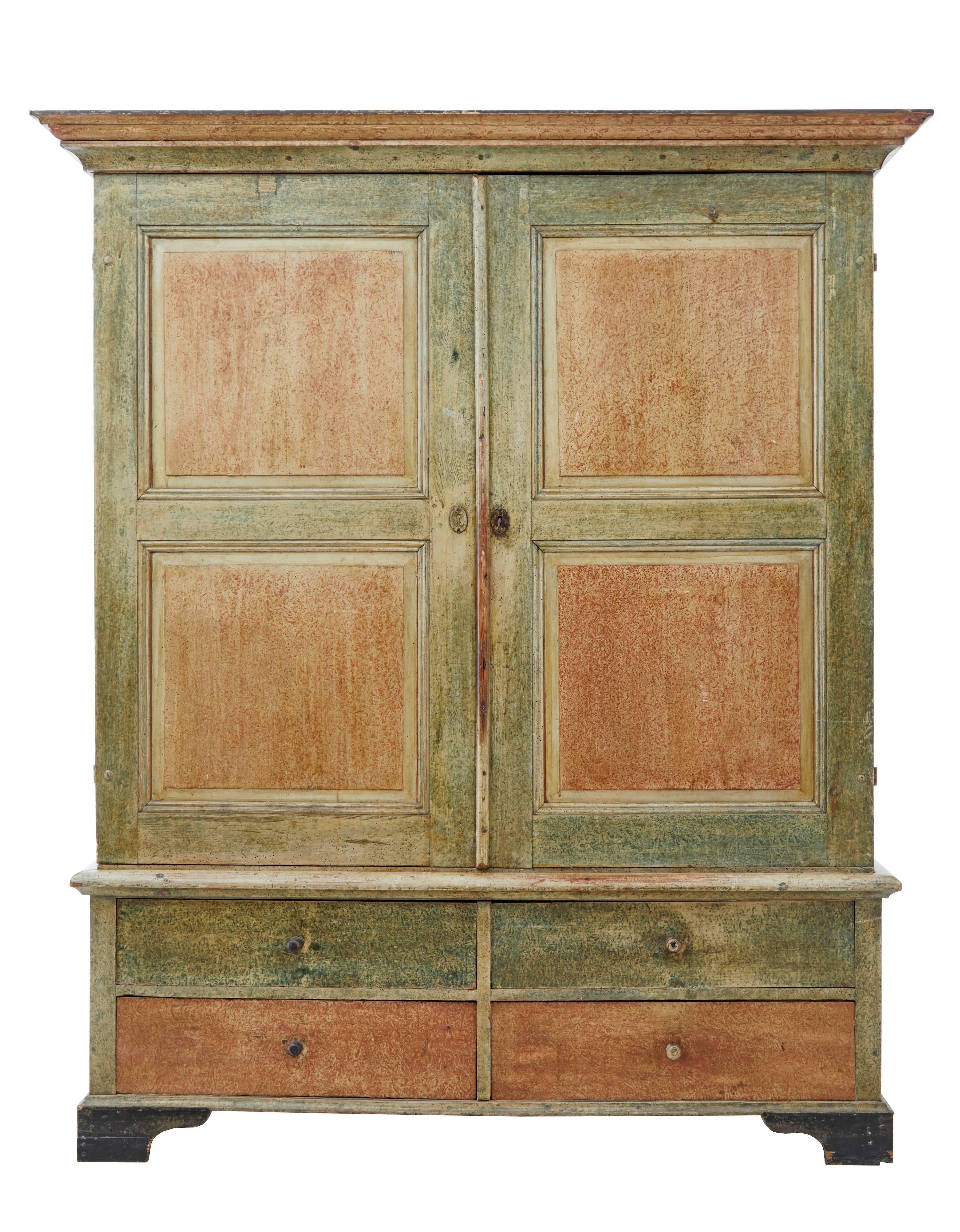 Mid-19th century Swedish pine cupboard on chest.
Original painted in rustic muted orange and greens.
Comprising of two parts.
Dated on the inside door 1860 with initials.
Top section with central partition, which has a wardrobe space with peg