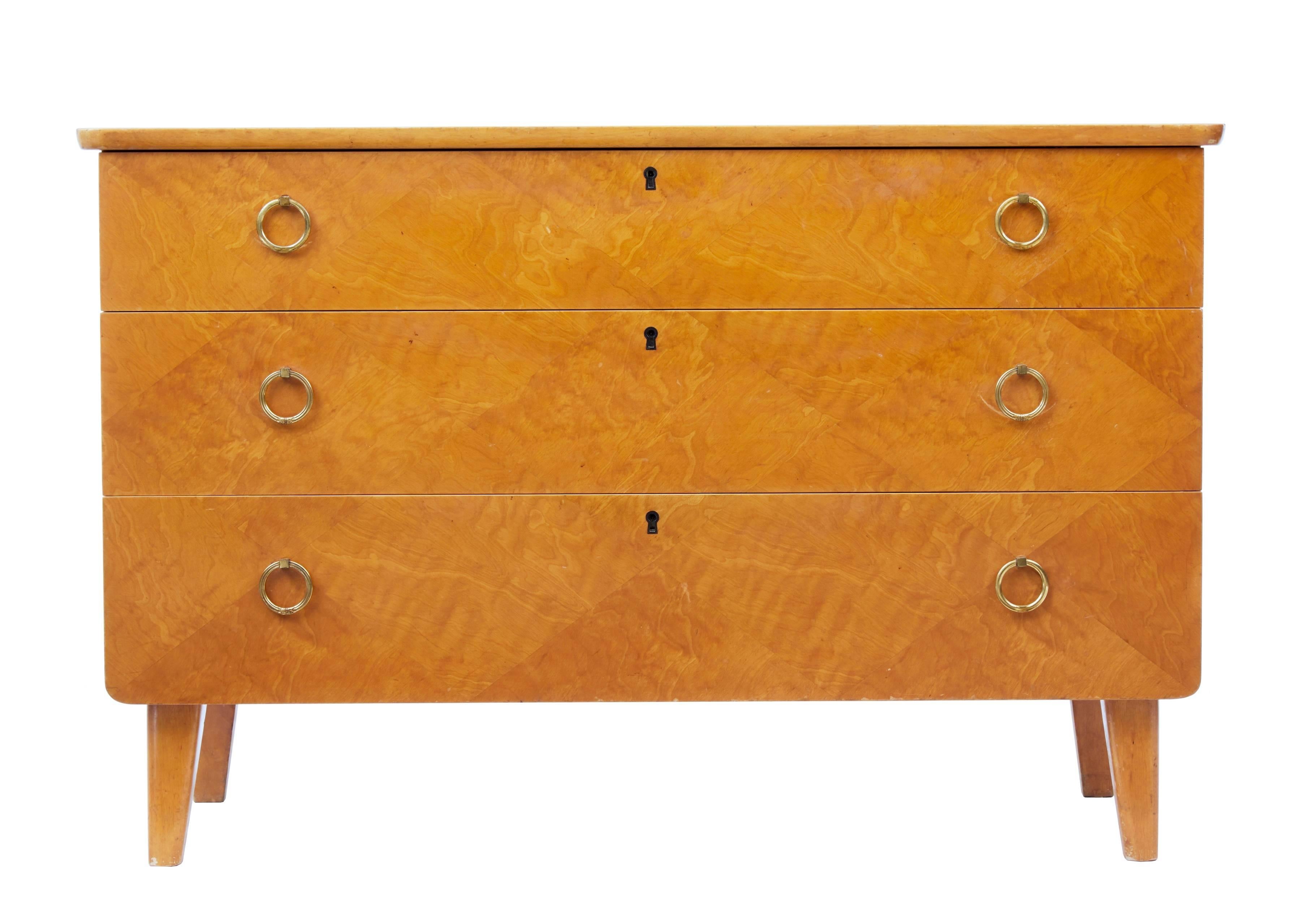 A fine looking birch chest of drawers, circa 1950.
Diamond patterned arrangement to the veneer on the drawer fronts.
Three drawers with brass looped handles.
Minor surface marks.


Measures: Height 25 1/2