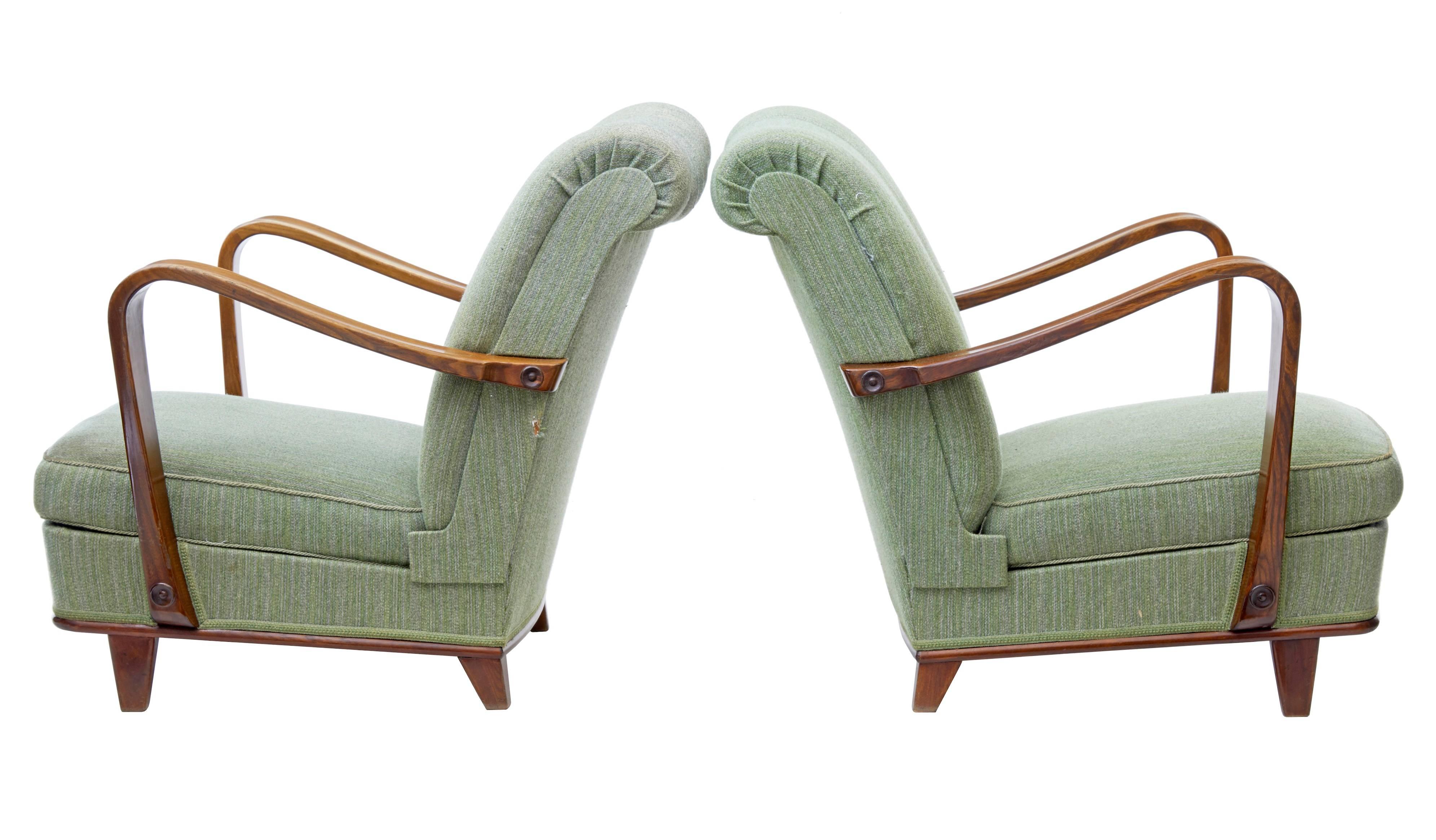 Fine pair of early 1960s shell back armchairs.
Low reclining seating position. Swooping birch arms provide the shape for the open side profile.
One hole to side of fabric and benefitting a clean. Otherwise perfectly useable.

Measures: Height 30