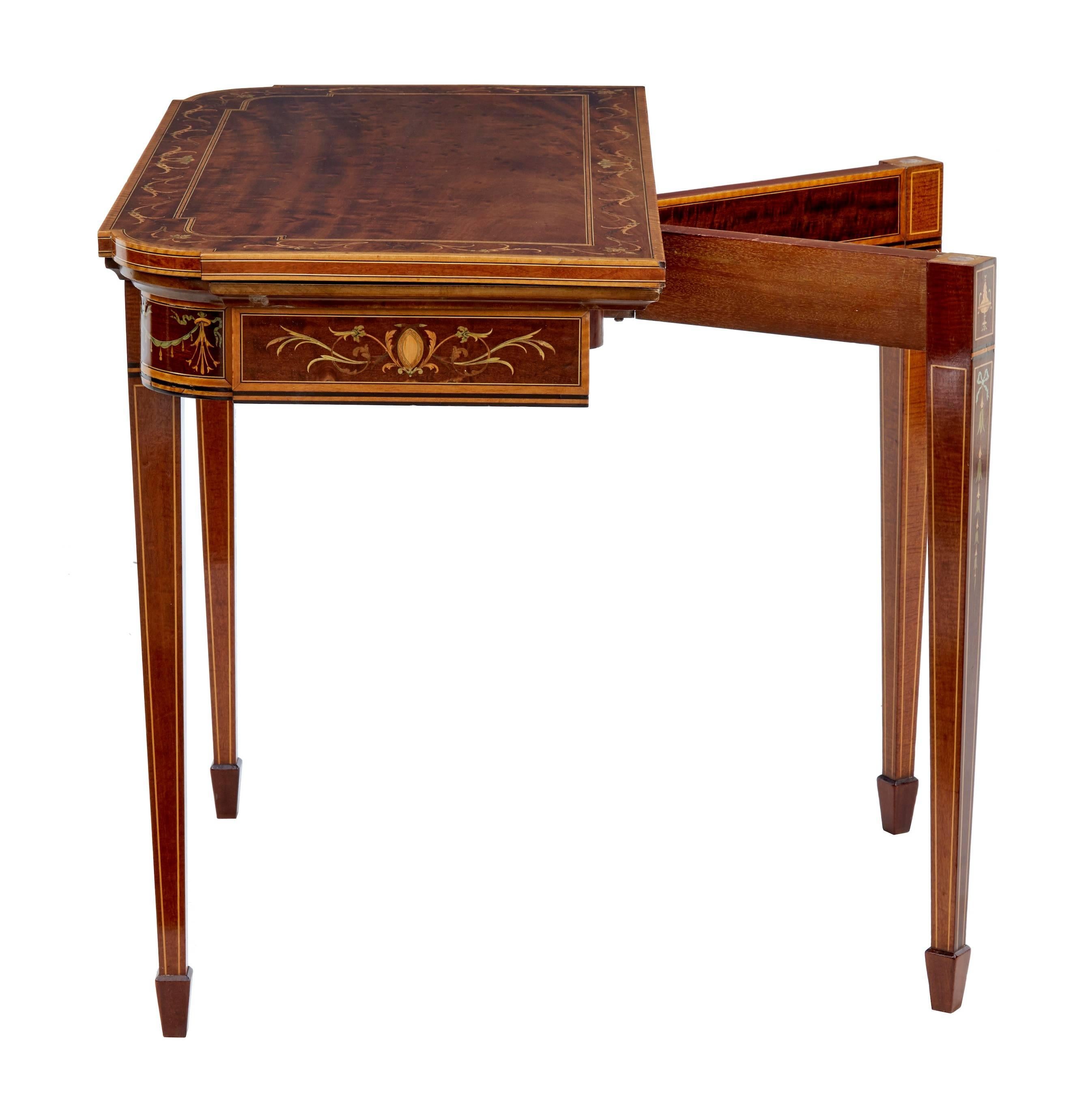 Fine quality card table made by renowned English makers Edwards and Roberts.
Beautiful plum pudding mahogany top inlaid with satinwood, boxwood, ebony and walnut.
Back legs swing out to allow the top to fold over to reveal a red playing