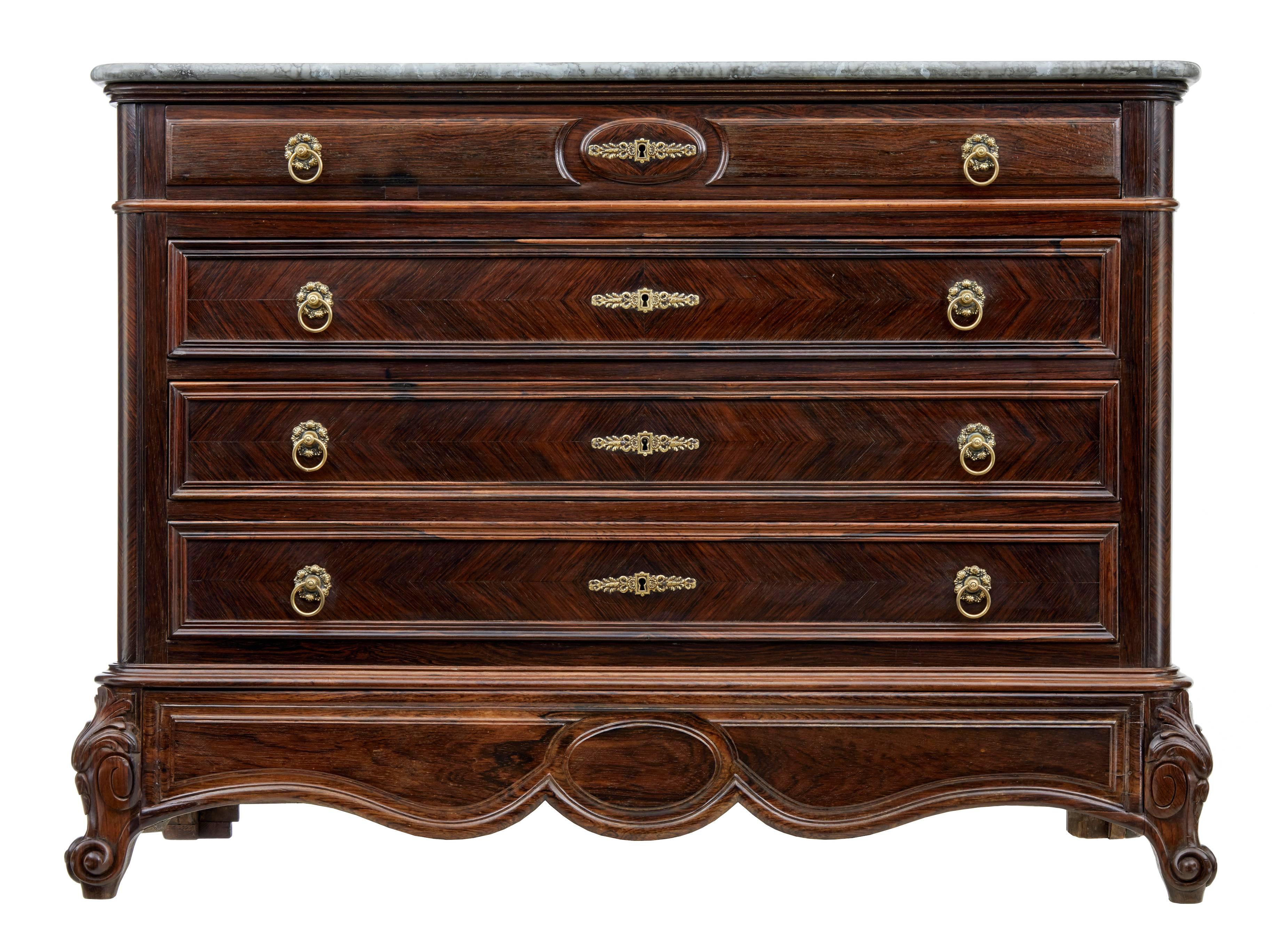Stunning French commode of grand proportions, circa 1860.
Four-drawer chest with original handles and hardware.
Later simulated marble top.
Striking matched rosewood veneers.
Shaped apron and standing on carved feet.

Measures: Height 38