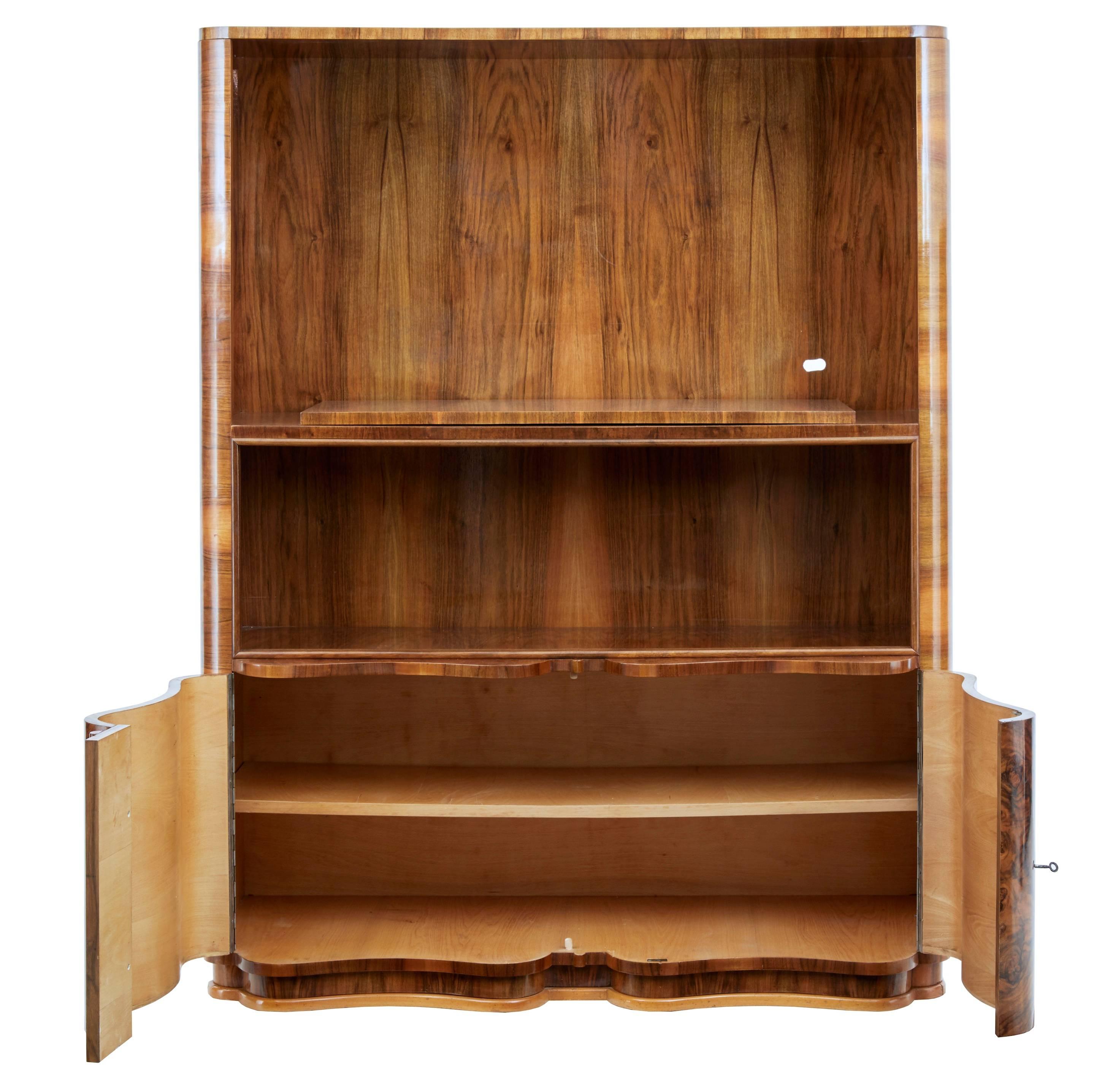 Late 1960s burr walnut veneered cabinet.
Strong color and striking grain.
Top section with platform with slight rotation ideal for a tv, below this an open space which would have had sliding doors which are no longer present.
Wave shaped double