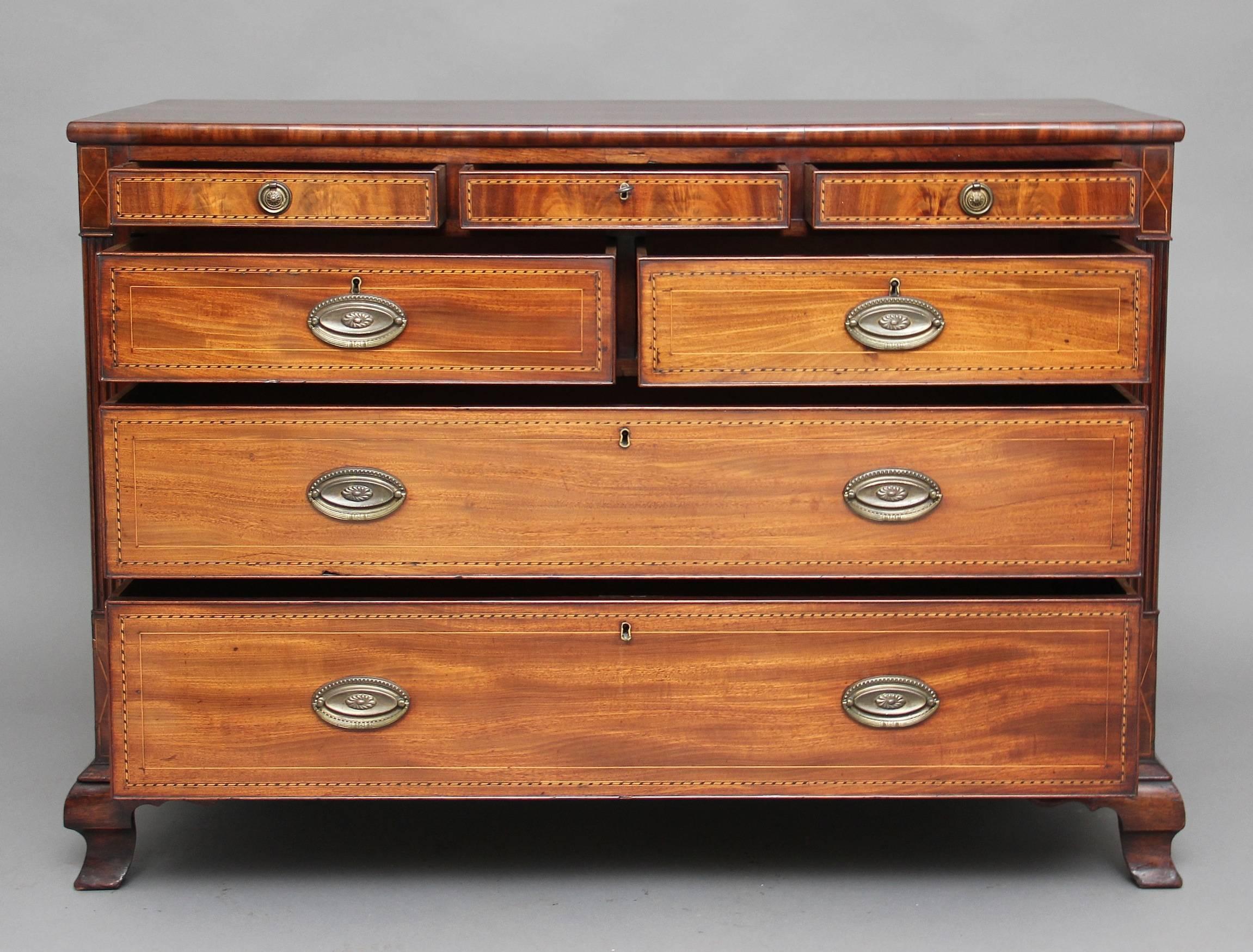 Early 19th century mahogany and chequer line-inlaid chest of drawers, the rectangular top above three small drawers with brass ring handles, and below a combination of two short over two long graduated drawers between fluted stiles, standing on ogee