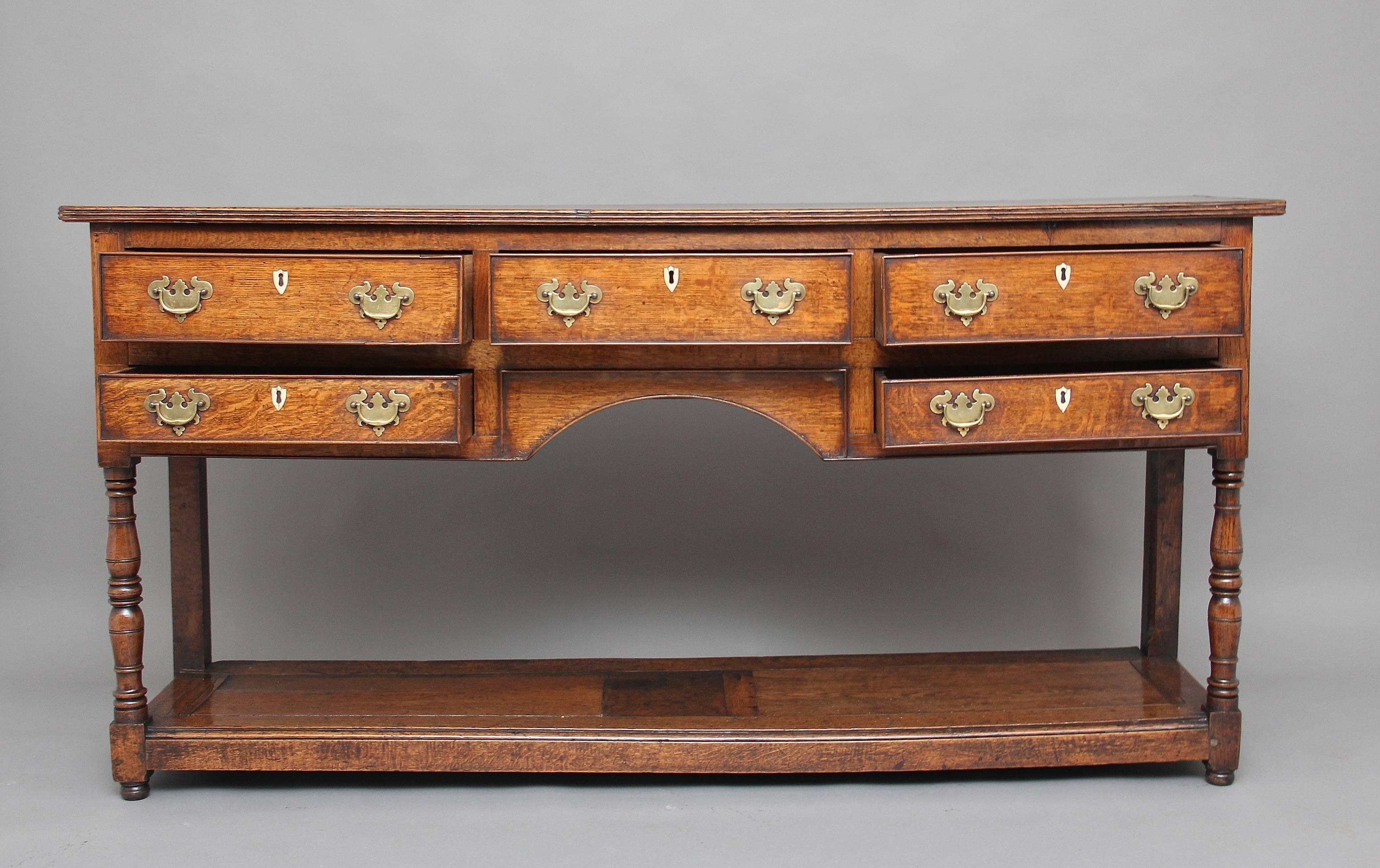 18th century oak potboard dresser base, the rectangular top having a reeded edge above a combination of three large over two small drawers, the top of the legs having a panel made from an exotic wood inlaid with ebony and boxwood, with a shaped