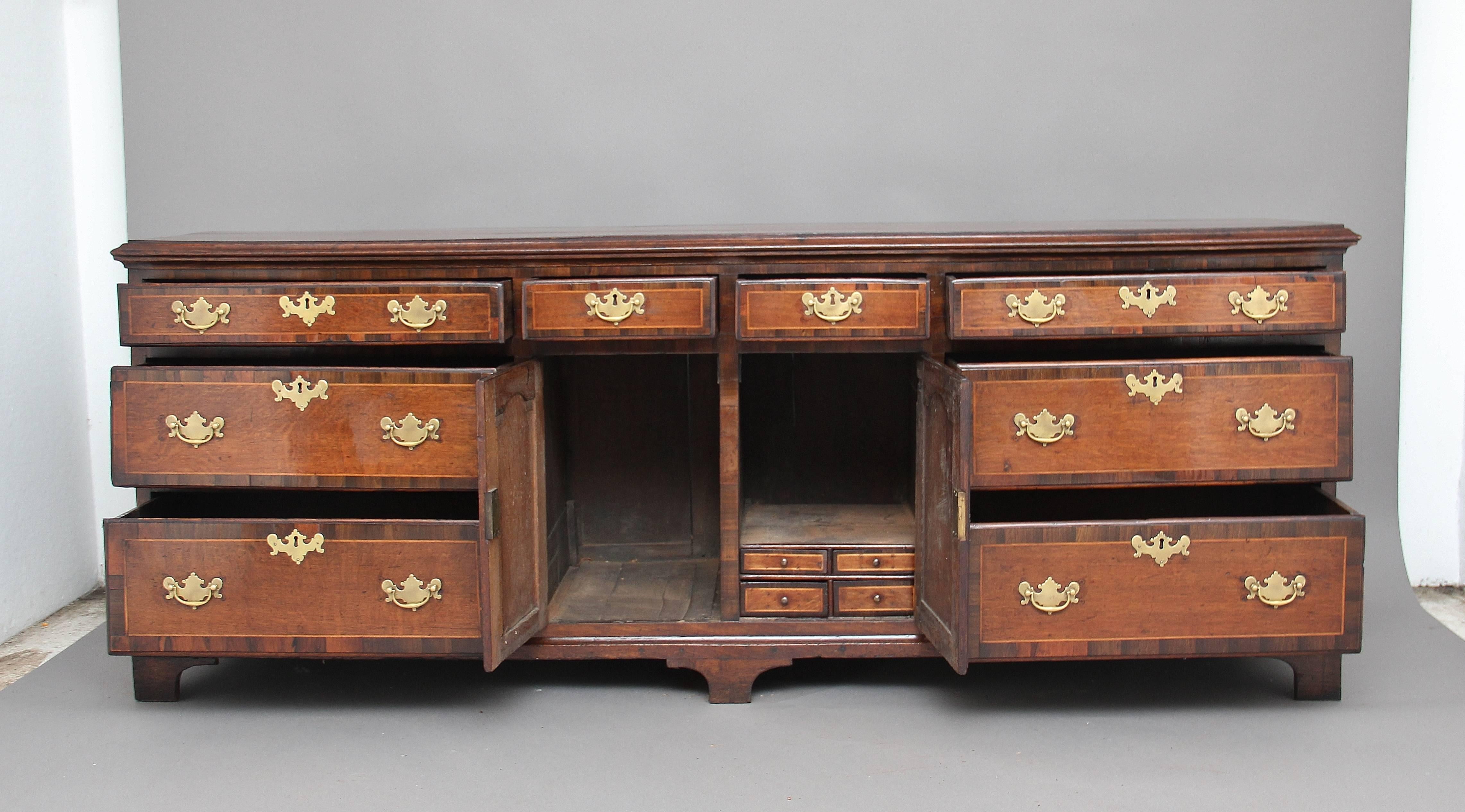 18th Century oak dresser base, the top cross banded in walnut with a thumb moulded edge above a selection of eight drawers, two small drawers at the top flanked either side by three graduated drawers, all drawers are cross banded in walnut and oak