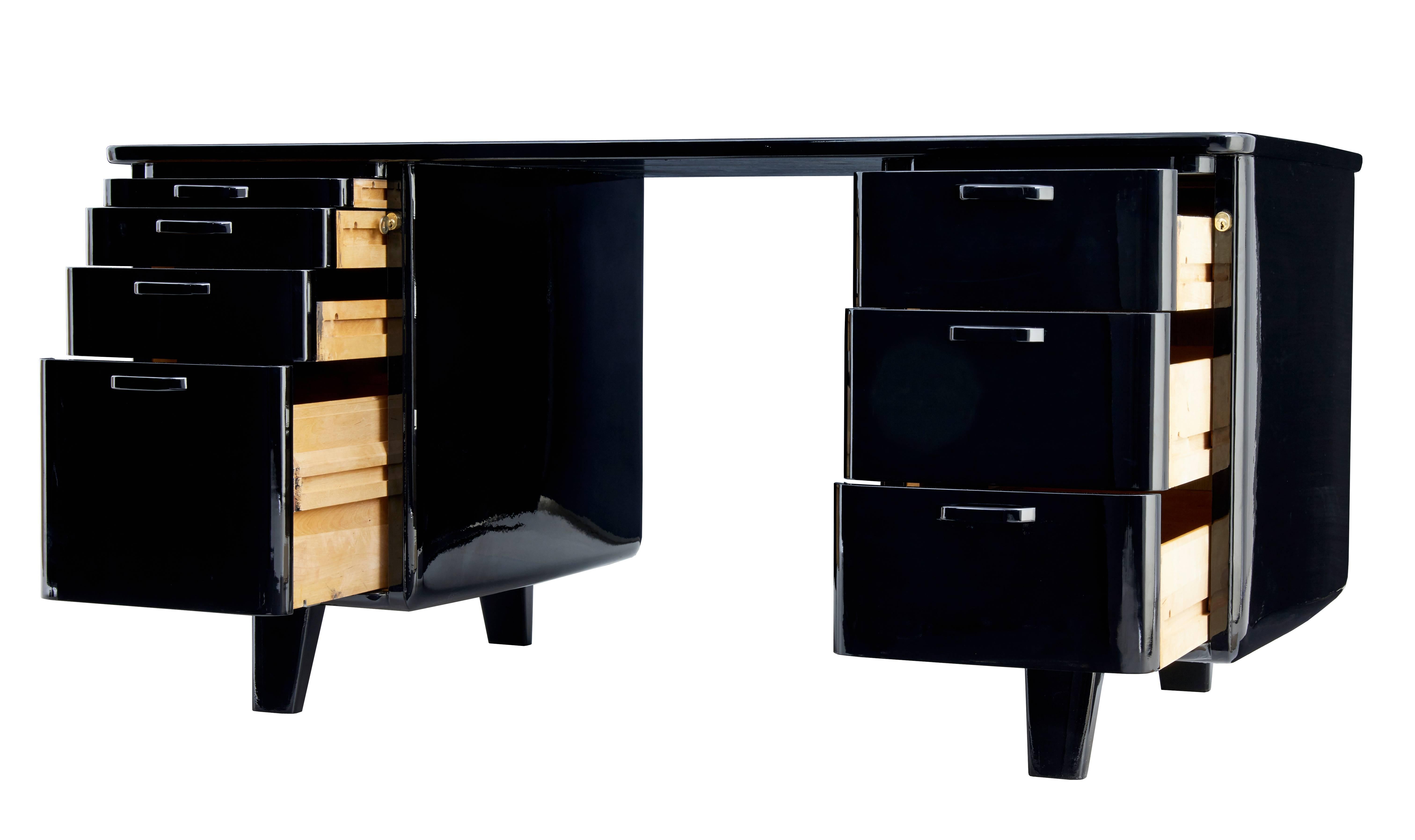 Stunning 1950s Scandinavian desk made by Atvidabergs in Sweden.
Presented in a high gloss black lacquer finish. Finished to a high standard all round which makes this desk freestanding.
Left hand drawers with top drawer forming a slide, three deep