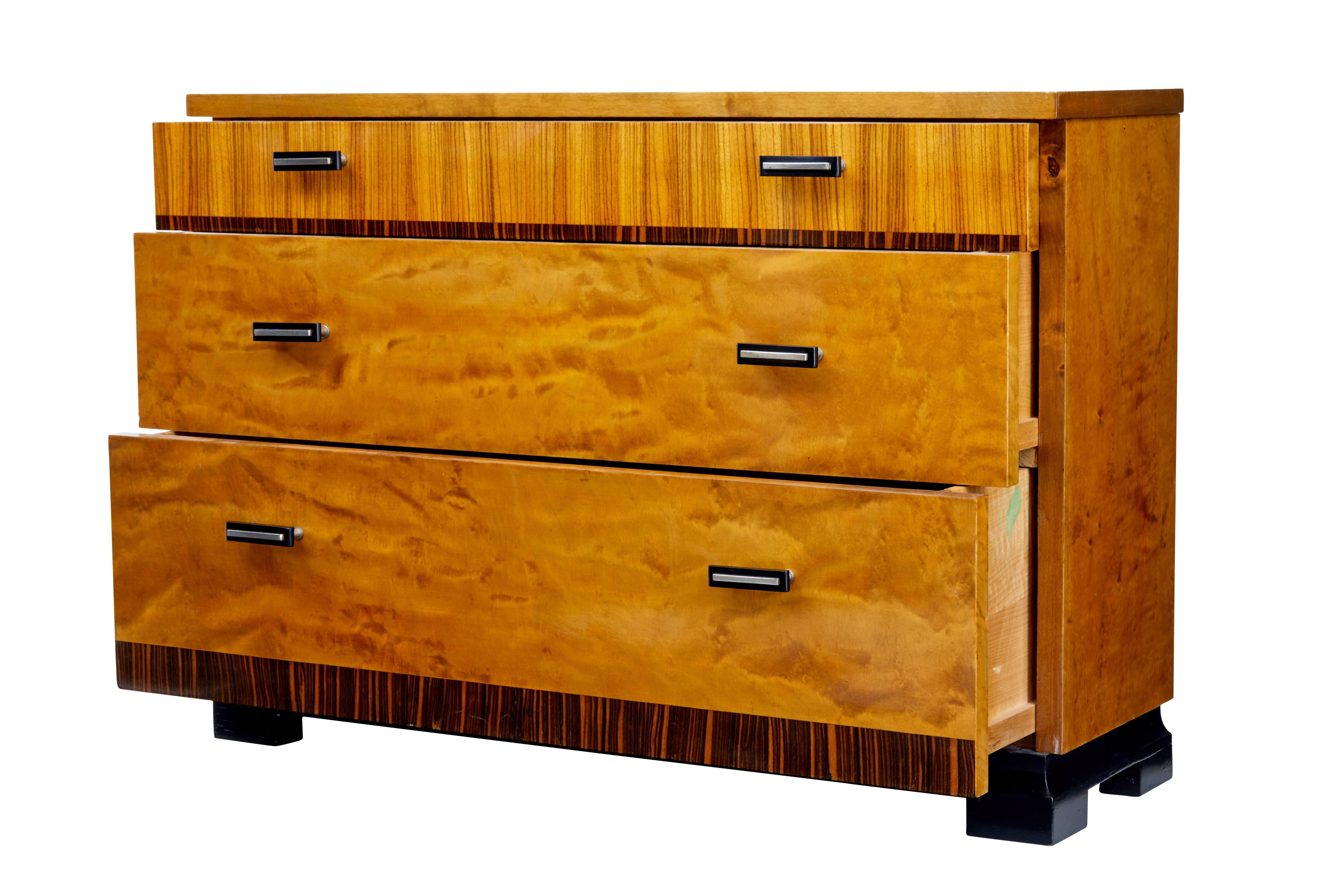 Stunning Art Deco inspired narrow chest of drawers, circa 1950.
Made with stunning birch and rosewood veneers. Standing on ebonized sledge feet.
Three graduating drawers with ebonized and steel handles.
Minor surface marks
Measures: Height 26