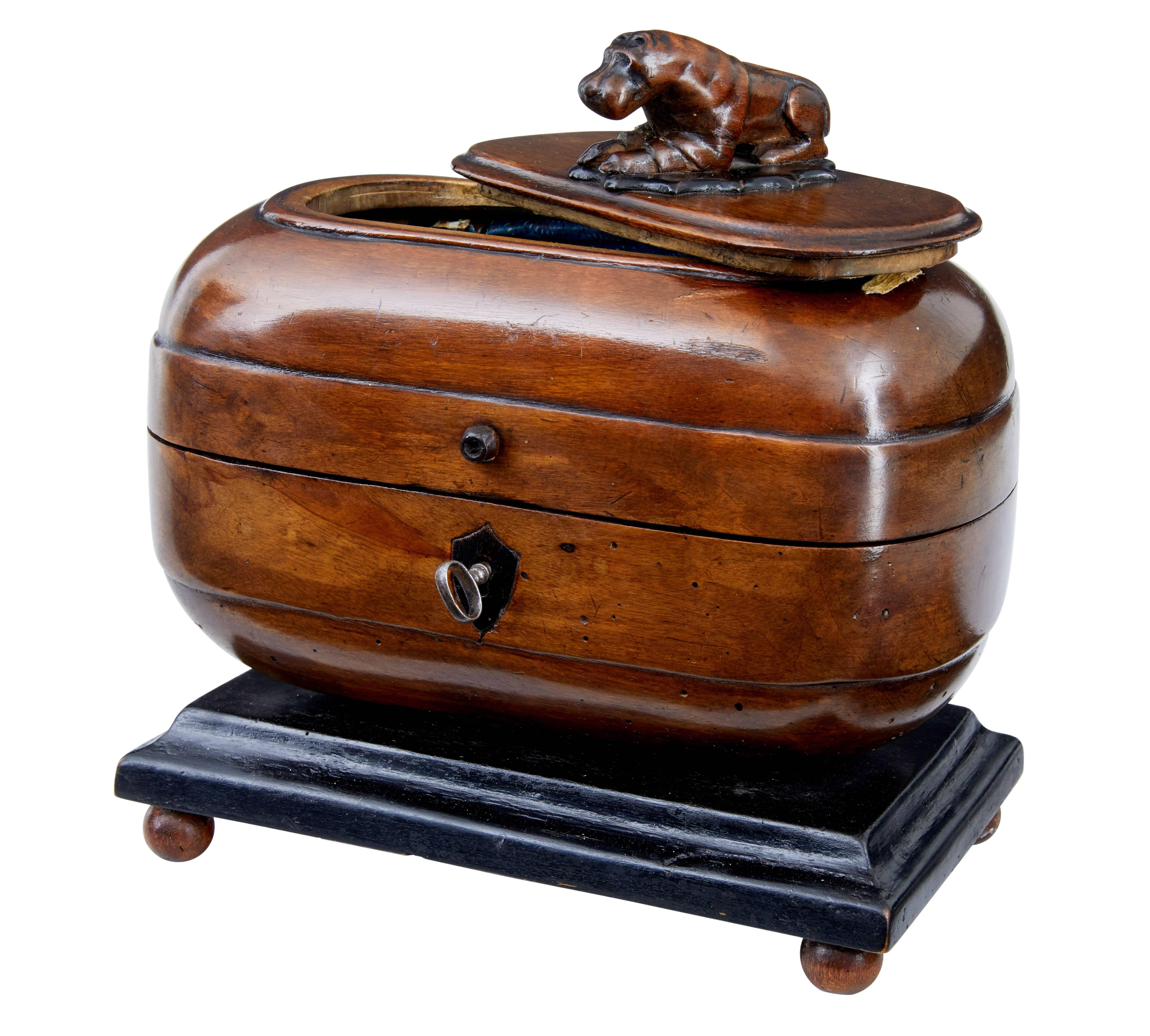 Rare fruitwood tea caddy, circa 1810.
Complete with a carved hippo on the lid which forms the handle to the top compartment.
Original lock and key opens the main storage vessel.
Later ebonized plinth and round feet.

Measures: Height 8
