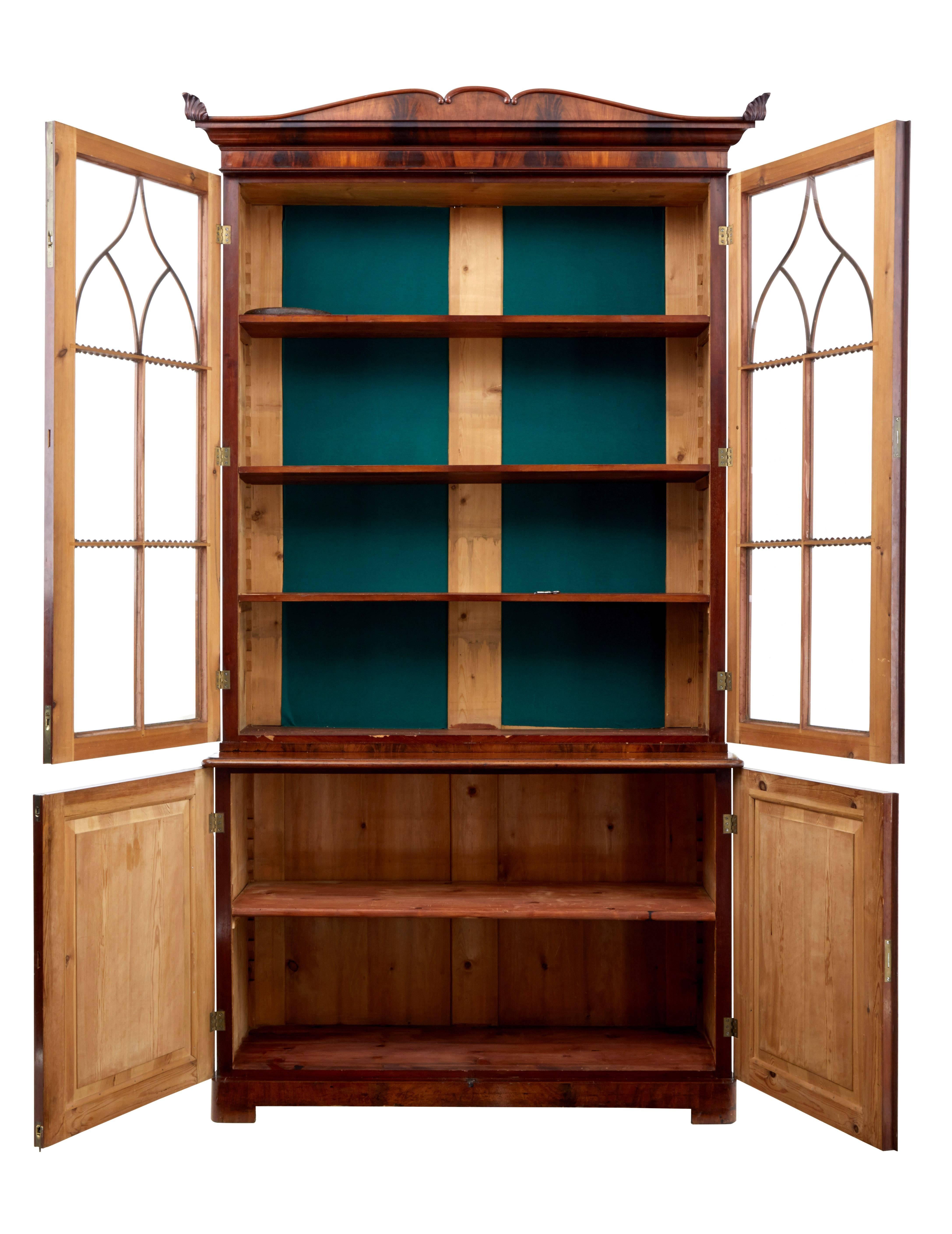 Beautiful quality flame mahogany bookcase from Sweden, circa 1830.
Comprising of three parts, cornice, glazed bookcase and lower cupboard.
Double door glazed cabinet with applied architectural applied moulding, opens to reveal three adjustable
