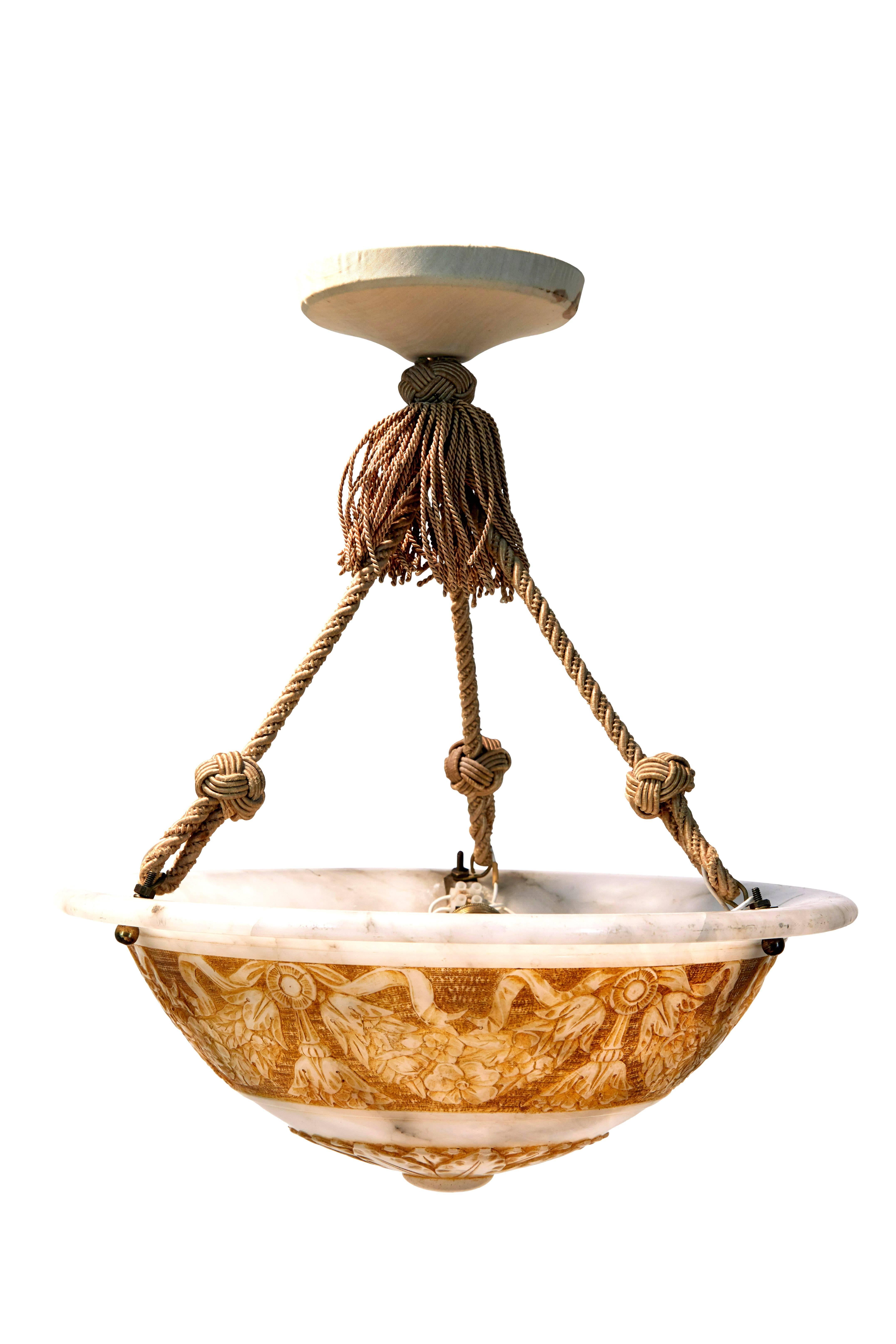 Beautiful carved alabaster ceiling light from the 1920s
Grey veined marble with contrasting carved florals and swags.
Suspended by three rope chains to the central fabric covered ceiling rose.
Fitted with three bulb holders.

Sold as untested,